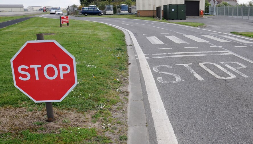 A stop sign is clearly visible to road users April 11, 2014, on a portion of South Perimeter Road by Taxiway Bravo on RAF Mildenhall, England. All vehicles on Perimeter Road must stop at the designated locations and remain in place if any aircraft is taxiing or being towed through the area. Vehicles must remain at the stop location until the aircraft has departed. (U.S. Air Force photo by Gina Randall/Released)