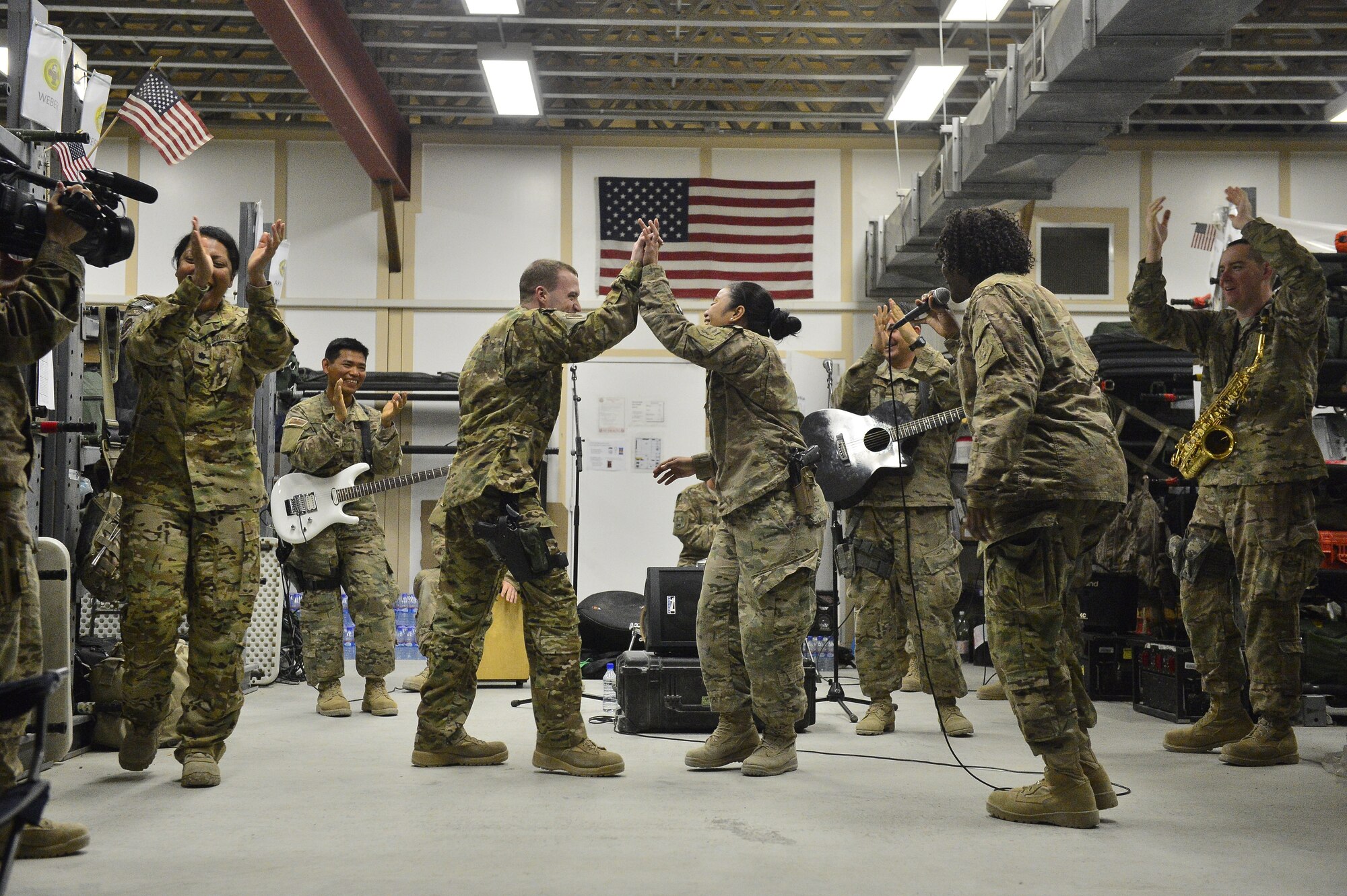 Members of the 455th Expeditionary Aeromedical Evacuation Squadron celebrate after dancing during a performance of the U.S. Air Forces Central Command Band April 11, 2014.  The band, Hypersonic, has a mission to entertain and uplift coalition forces throughout the region (U.S. Air Force photo/Staff Sgt. Vernon Young)