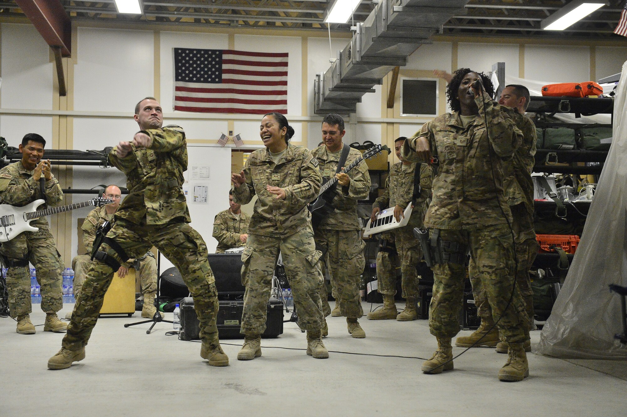 U.S. Air Force Tech. Sgt. Amber Grimes, right, performs with the U.S. Air Forces Command Band while members of the 455 Expeditionary Aeromedical Evacuation Squadron dance at Bagram Air Base April 11, 2014. The AFCENT Band, Hypersonic, deployed out of Yokota Air Base Japan recently completed a 17 day tour of the region performing for joint service members and coalition forces. (U.S. Air Force photo/Staff Sgt. Vernon Young)