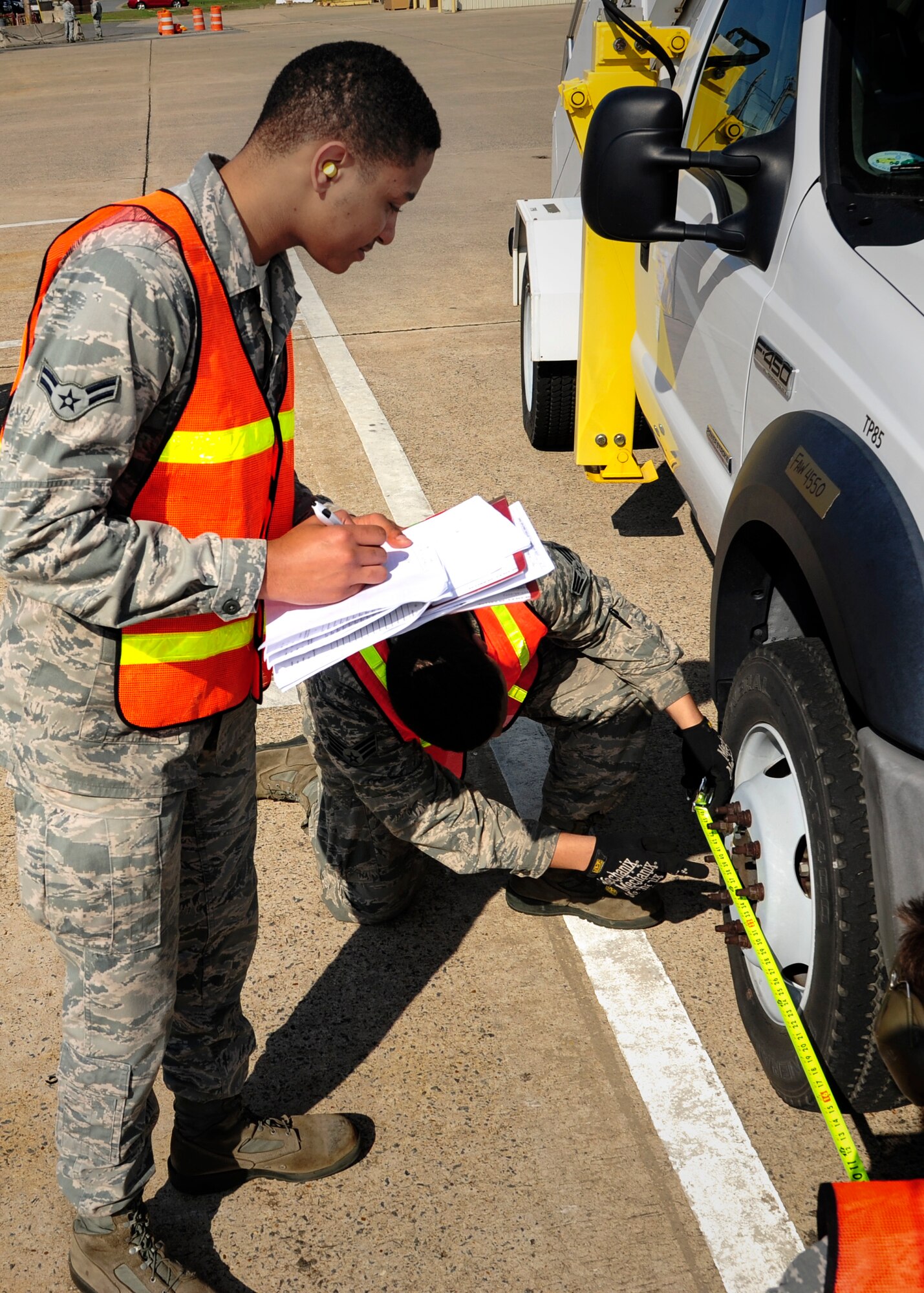 Airman 1st Class Jerrod Holleman, 19th Logistics Readiness Squadron transportation management office journeyman, writes down the measurement of a wheel well to determine a truck’s center of gravity April 22, 2014, at Little Rock Air Force Base, Ark. The truck was weighed and measured as part of a mock mass-deployment exercise. (U.S. Air Force photo by Airman 1st Class Harry Brexel)