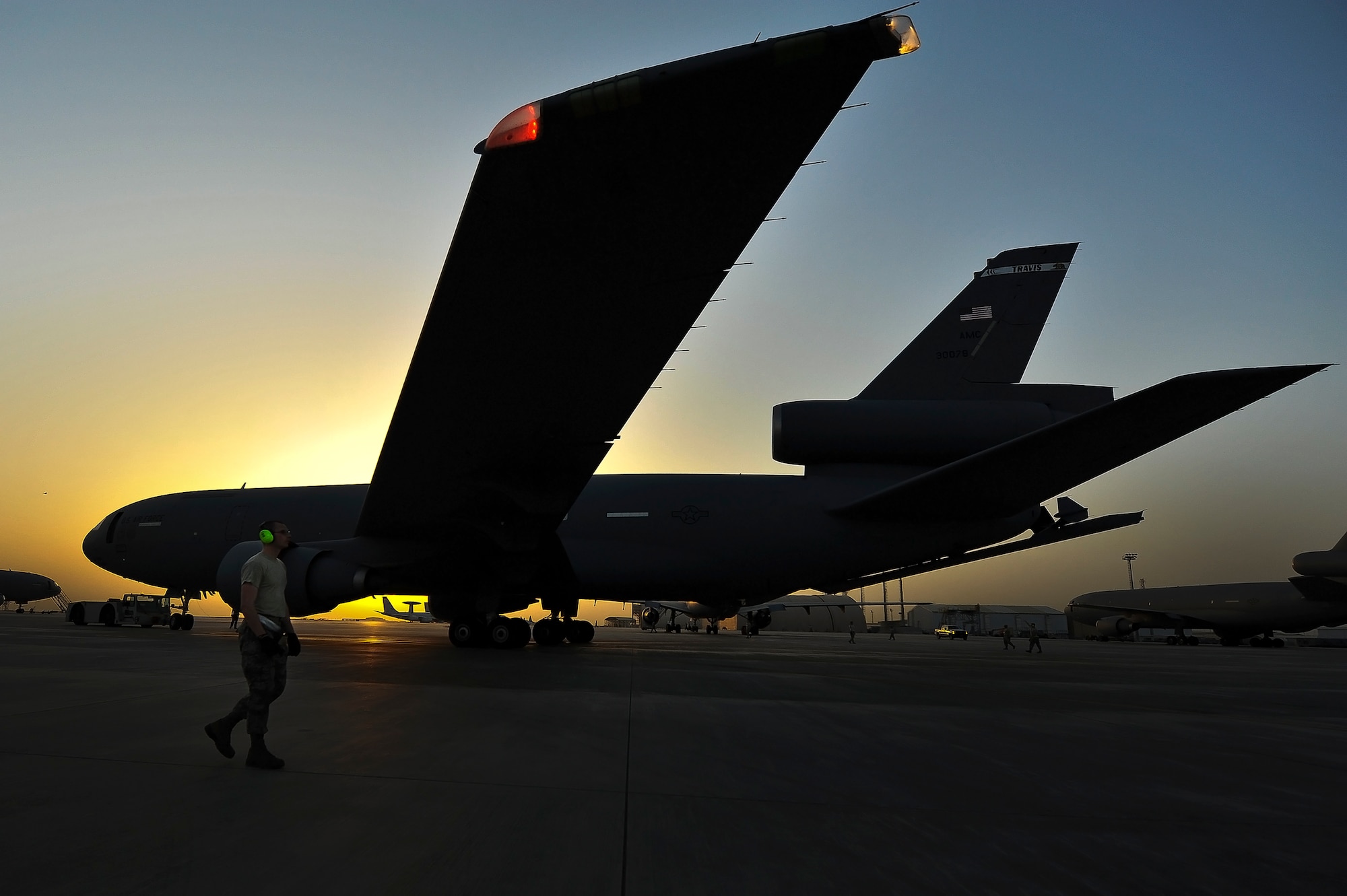 A 380th Expeditionary Maintenance Group crew chief performs tow team duties April 28, 2014, at an undisclosed location in Southwest Asia. The maintainer walks along the aircraft near the wing tips to ensure they do not come into contact with taxiing jets. (U.S. Air Force photo byTech. Sgt. Russ Scalf/Released)
