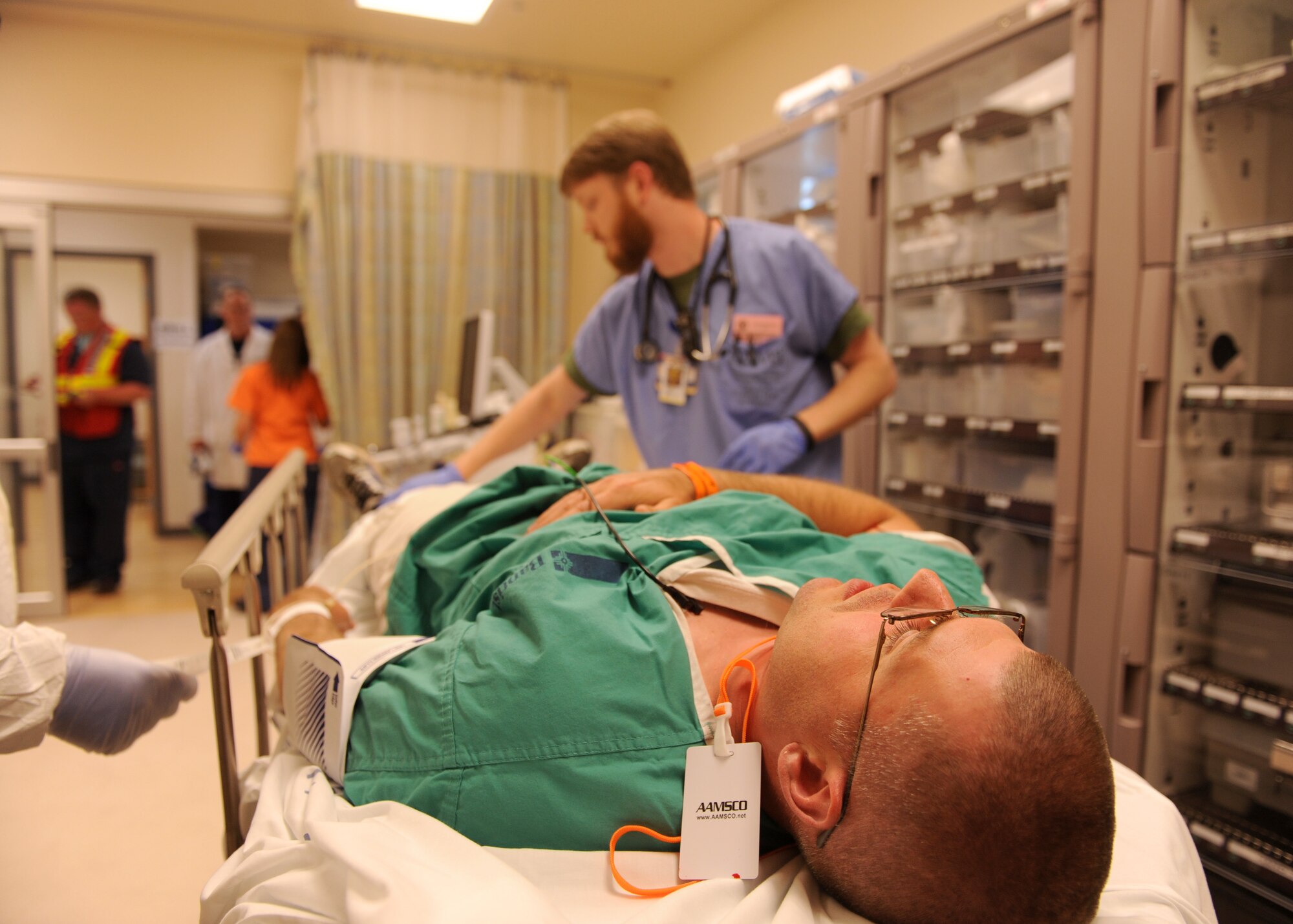 A Little Rock Air Force Base Airman lays on a gurney as a simulated victim during a major accident response exercise at the University of Arkansas for Medical Sciences campus April 22, 2014. Doctors, nurses and other medical personnel simulated medical procedures during the MARE. (U.S. Air Force photo by Airman 1st Class Scott Poe)