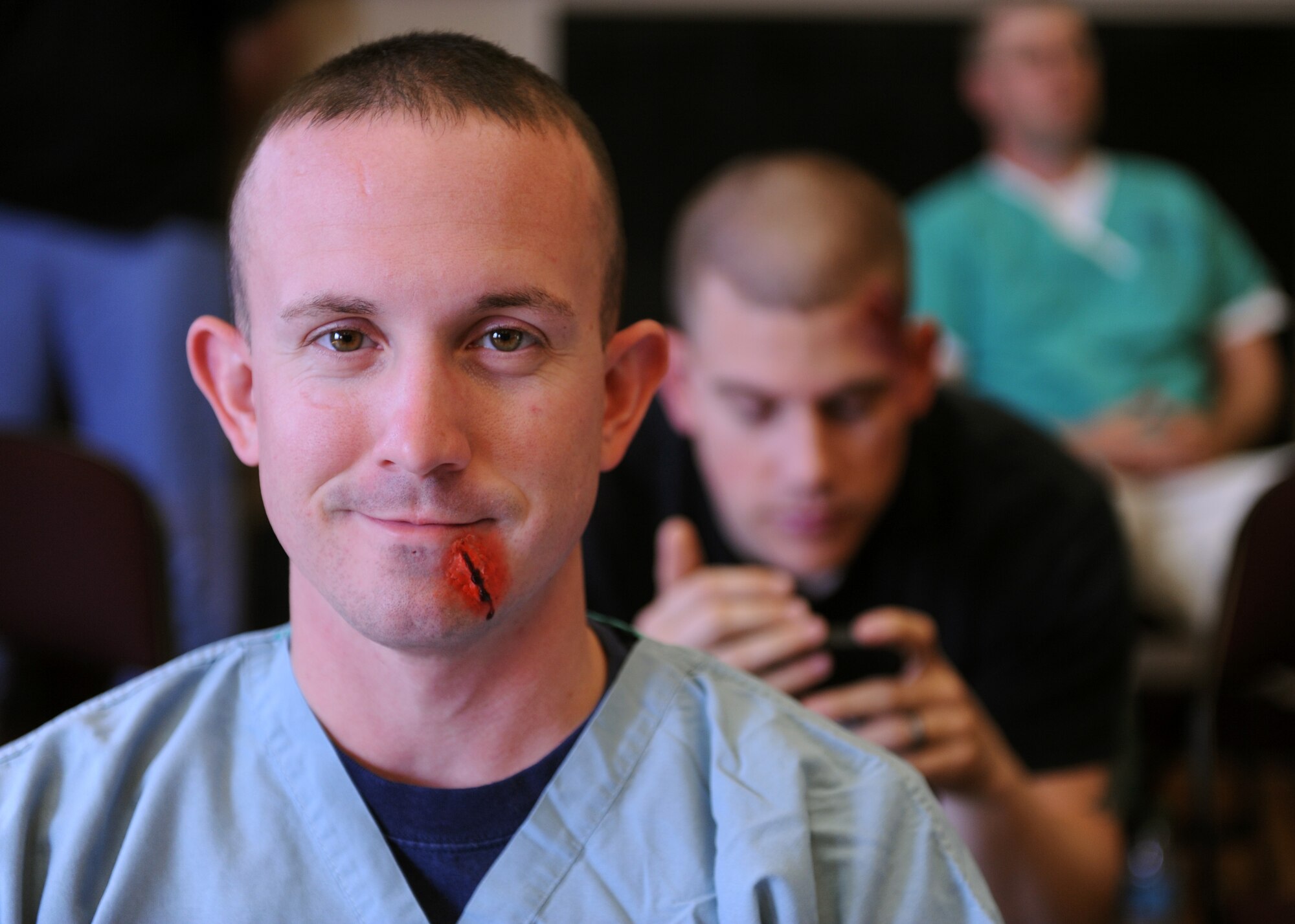 A Little Rock Air Force Base Airman smiles after having moulage applied to his face to simulate an injured casualty for an exercise at the University of Arkansas for Medical Sciences campus April 22, 2014. The exercise was held at the University of Arkansas for Medical Sciences campus and was the largest of its type to date with more than 30 local, state and federal agencies involved. (U.S. Air Force photo by Airman 1st Class Scott Poe)