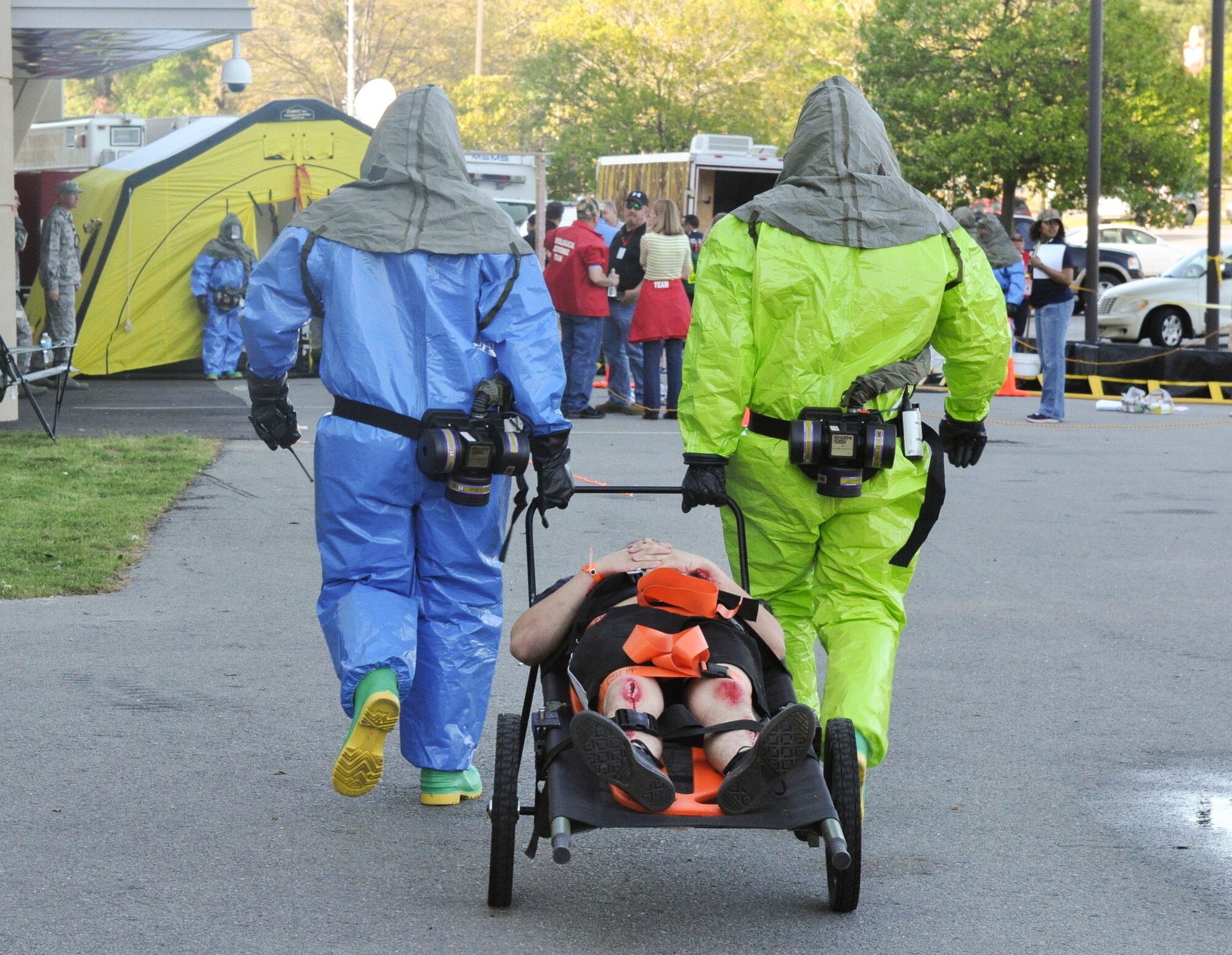 Participants of a field training exercise transport a Little Rock Air Force Base Airman with simulated injuries to the decontamination tent April 22, 2014. Airmen from the base simulated roles as hostages, injured victims of an explosion and victims exposed to radiation. (U.S. Air Force photo by Senior Airman Regina Agoha)