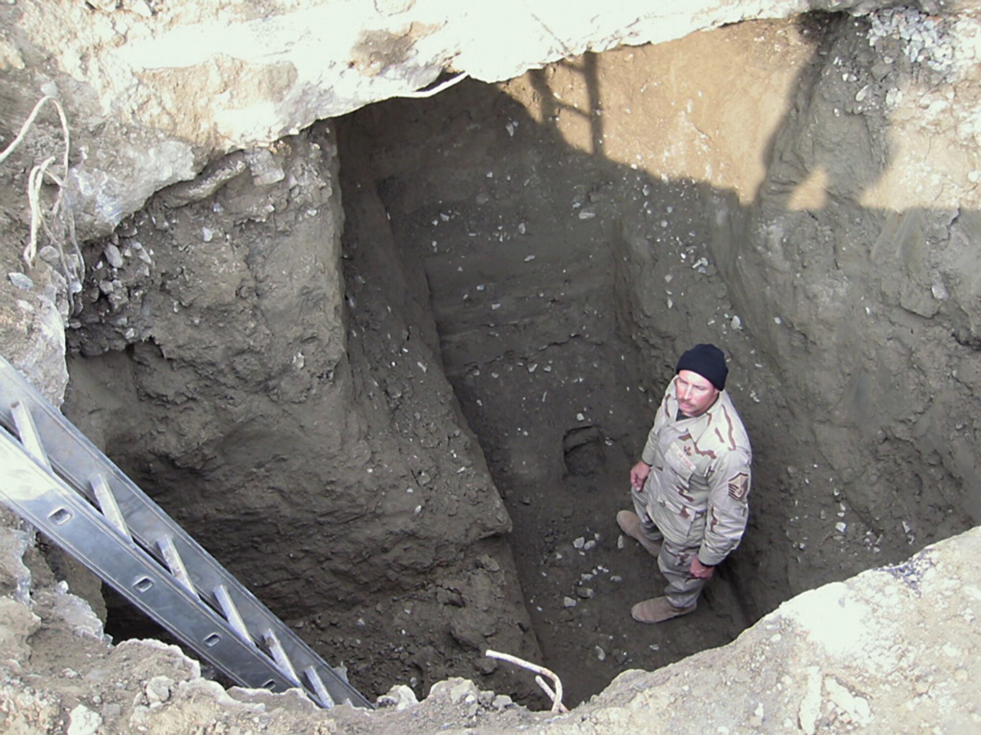 Then Master Sgt. James Brewster, 379th Expeditionary Civil Engineer Squadron, stands in an excavated pit to locate the entry route of an unexploded ordnance beneath a runway in Afghanistan Jan. 6, 2004. On June 1, 2014, now Chief Master Sgt. Brewster and Air Force EOD career field manager retires, ending a 31-year career in the Air Force that included 12 deployments and hundreds of EOD missions supporting joint service operations. (U.S. Air Force photo)