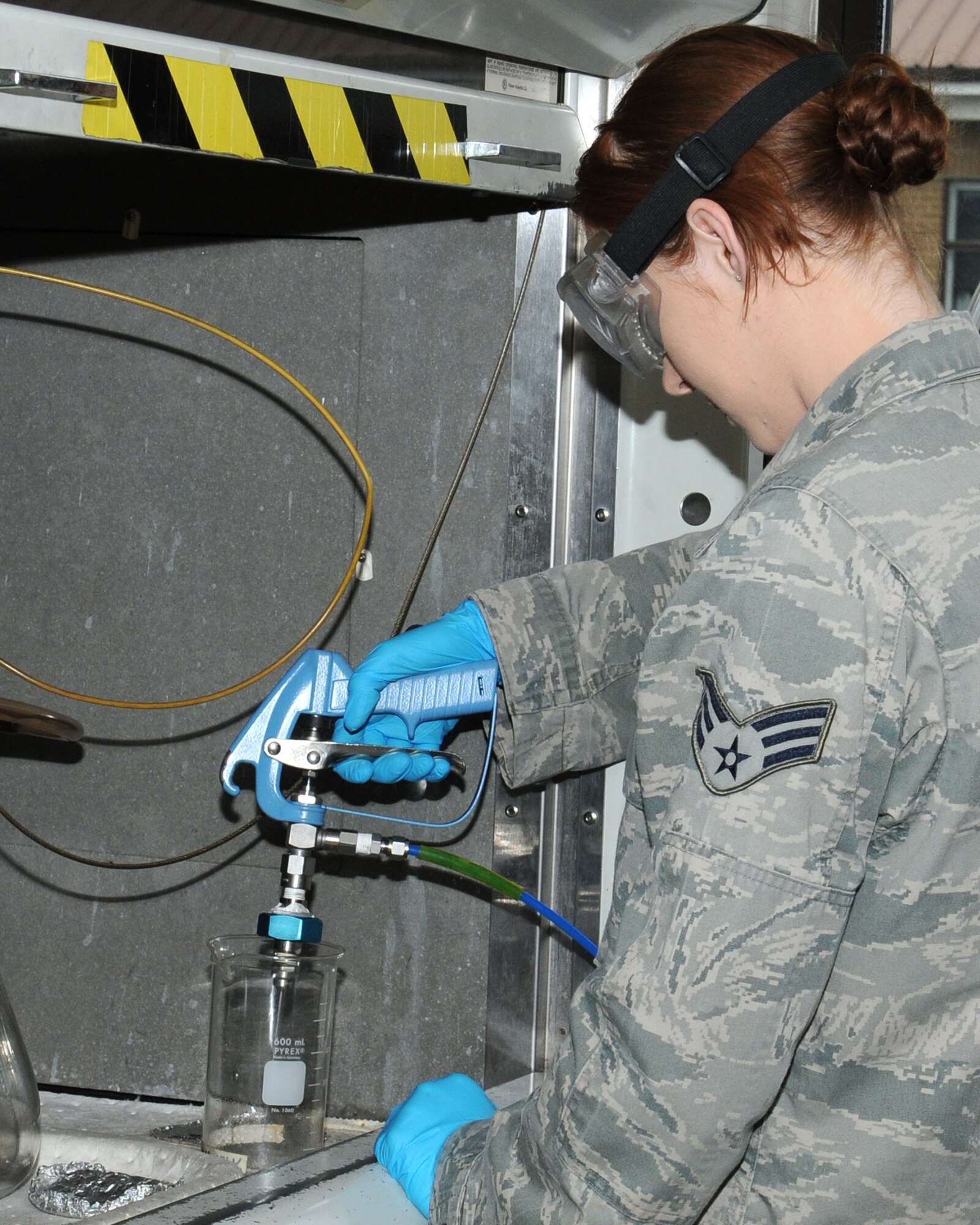 U.S. Air Force Senior Airman Megan McMinn, 100th Logistics Readiness Squadron Fuels Laboratory technician from Houston, performs a bottle-method test April 22, 2014, on RAF Mildenhall, England. McMinn ensured the received aviation fuel was free of particulate matter. The fuels laboratory technicians conduct this test daily to ensure the base issues the highest quality aviation fuel to home station and transient aircraft. (U.S. Air Force photo by Gina Randall/Released)