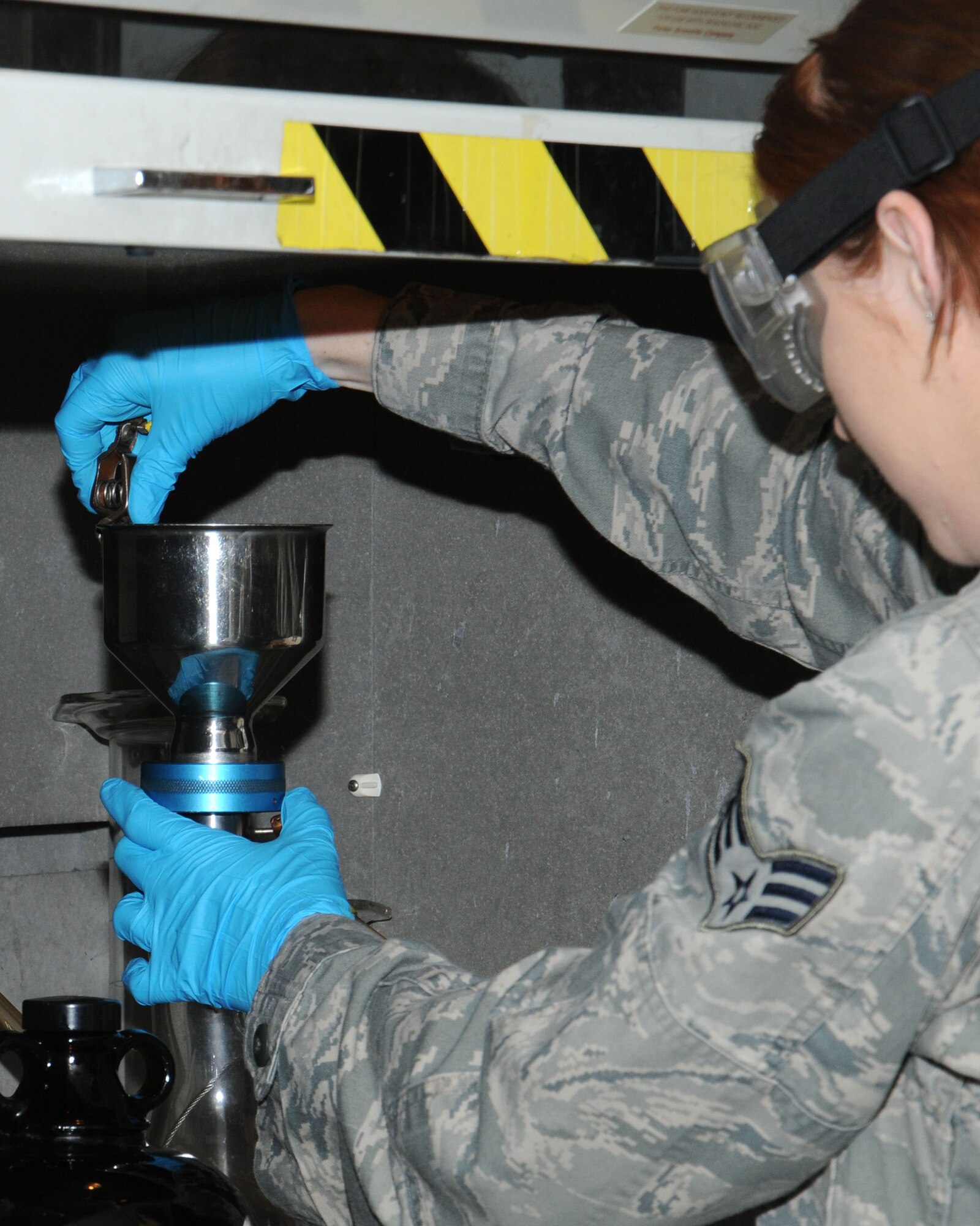 U.S. Air Force Senior Airman Megan McMinn, 100th Logistics Readiness Squadron Fuels Laboratory technician from Houston, performs a bottle-method test on aviation fuel April 22, 2014, on RAF Mildenhall, England. McMinn checked the solids content in the aviation fuel to ensure the delivery is free of particulate matter. (U.S. Air Force photo by Gina Randall/Released)