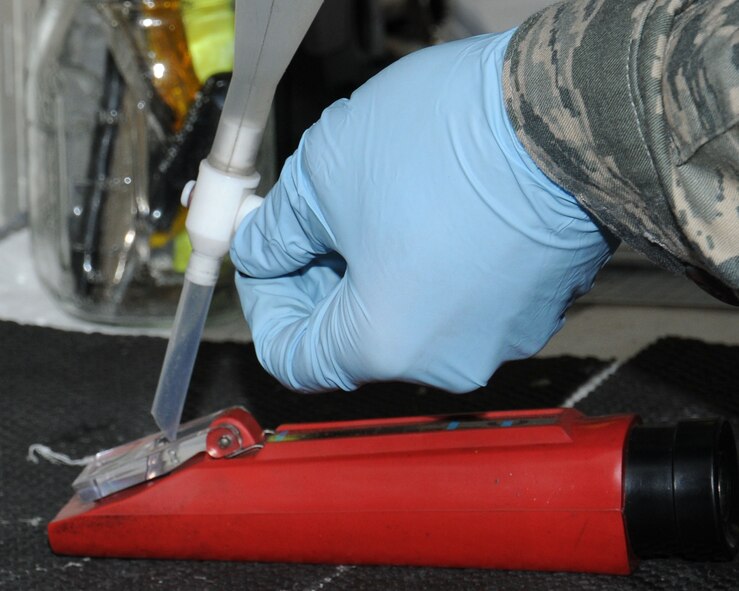 U.S. Air Force Senior Airman Zachary Mandeville, 100th Logistics Readiness Squadron Fuels Laboratory technician from North Smithfield, R.I., tests fuel system icing inhibitor content in a jet fuel sample April 22, 2014, on RAF Mildenhall, England. The fuels laboratory team completes this sampling daily to ensure the base is receiving and issuing quality jet fuel. (U.S. Air Force photo by Gina Randall/Released)