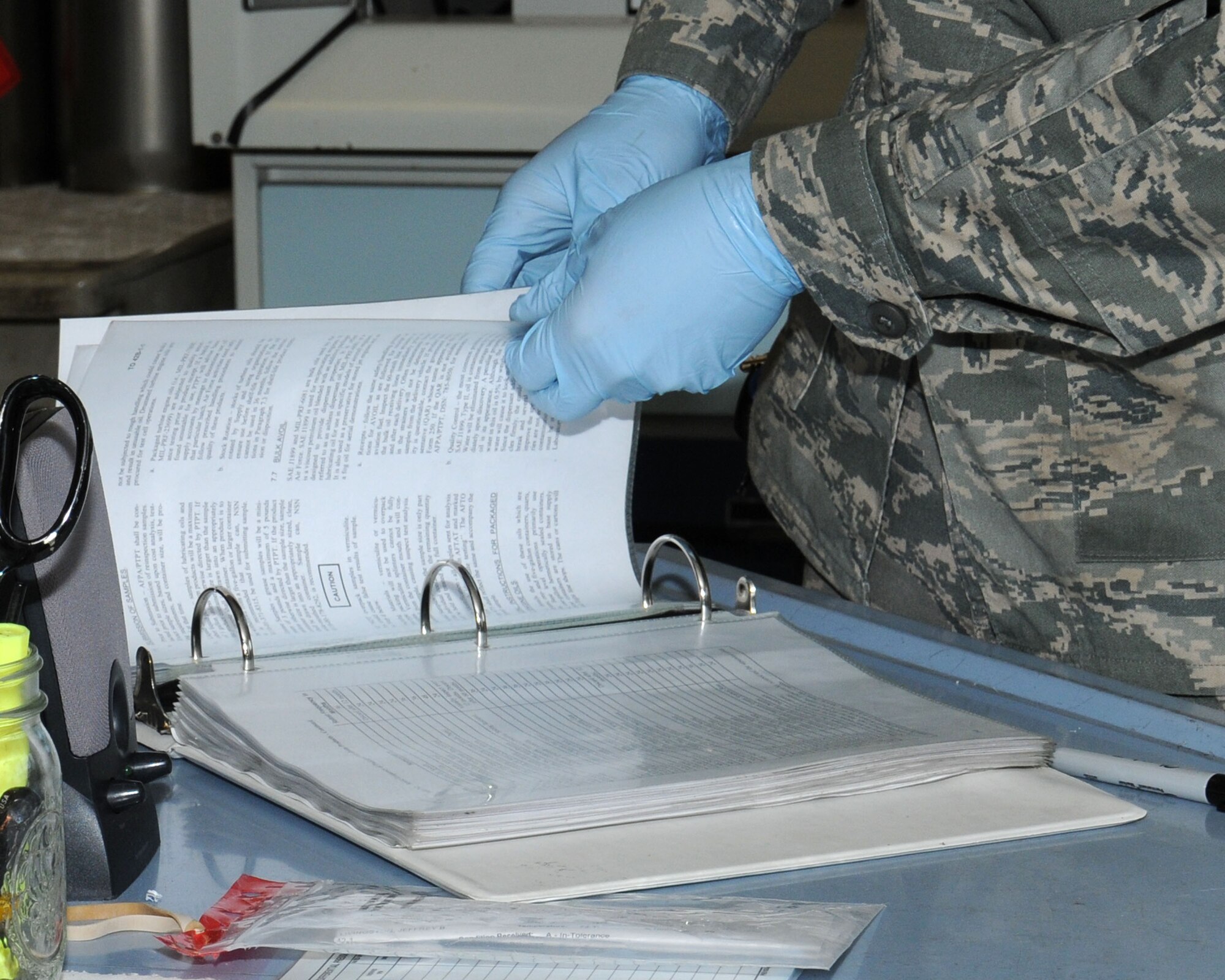 U.S. Air Force Senior Airman Zachary Mandeville, 100th Logistics Readiness Squadron Fuels Laboratory technician from North Smithfield, R.I., references a technical order April 22, 2014, on RAF Mildenhall, England. Mandeville used the T.O. to check the results from a fuel system icing inhibitor sample test. (U.S. Air Force photo by Gina Randall/Released)