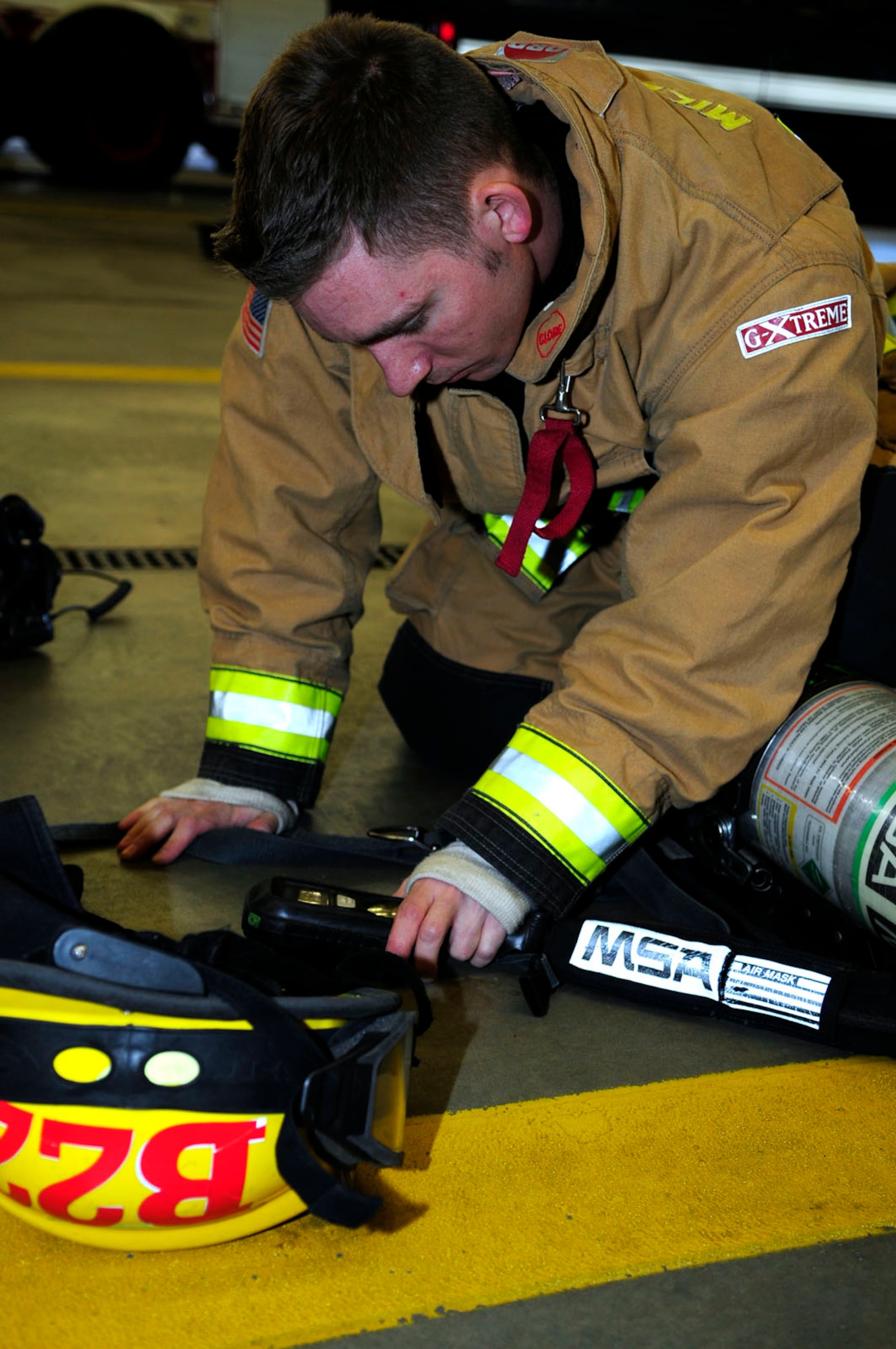 U.S. Air Force Tech. Sgt. Noah Leiter, 100th Civil Engineer Squadron Fire Department assistant chief of fire prevention from Carthage, Mo., checks the oxygen monitor on his self-contained breathing apparatus during training April 14, 2014, on RAF Mildenhall, England. All 100th CES firefighters are performing SCBA training throughout April. In addition to reviewing a written training plan, they have to complete a course of six stations while working in pairs, including carrying a simulated casualty, using a rope to hoist a rolled hose to the top of a flight of stairs, and climbing up and down a ladder twice, all while wearing an SCBA and full personal protective equipment. (U.S. Air Force photo by Karen Abeyasekere/Released)