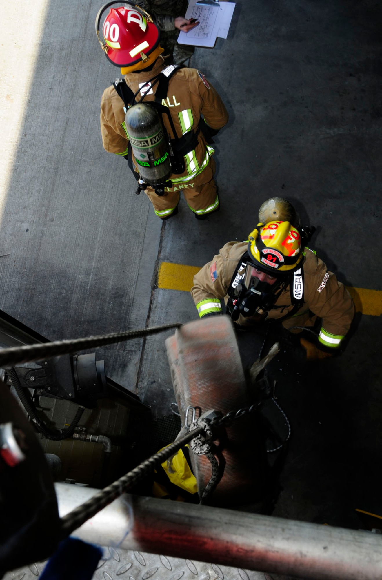 Firefighter Jason French, 100th Civil Engineer Squadron Fire Department from Lakenheath, Suffolk, hoists a 50-pound rolled hose during self-contained breathing apparatus training April 14, 2014, at the fire department on RAF Mildenhall, England. In accordance with National Fire Protection Act Standard 1404, all fire departments must provide annual respiratory protection training for all members. RAF Mildenhall firefighters are in the process of completing the training. In addition to reviewing a written training plan, all 100th CES firefighters are completing thorough "hands-on" training to ensure they know exactly how to use their SCBA safely when an emergency occurs. (U.S. Air Force photo by Karen Abeyasekere/Released)