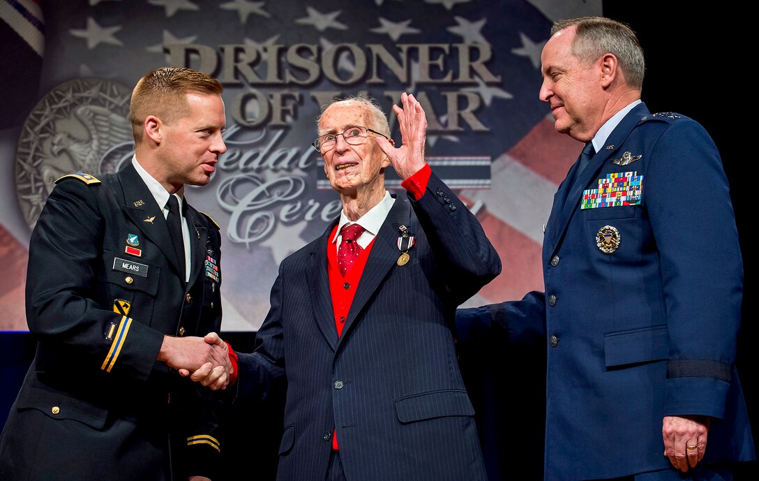 Air Force Chief of Staff Gen. Mark A. Welsh III, right, presents the Prisoner of War medal to Army Air Corps 1st Lt. James Mahon as Army Maj. Dwight Mears shakes Mahon's hand during a ceremony at the Pentagon, April 30, 2014. Mahon and seven other aviators, all bomber crew members shot down flying missions over Germany, were held in a prison camp in Wauwilermoos, Switzerland. The men originally were denied POW status.