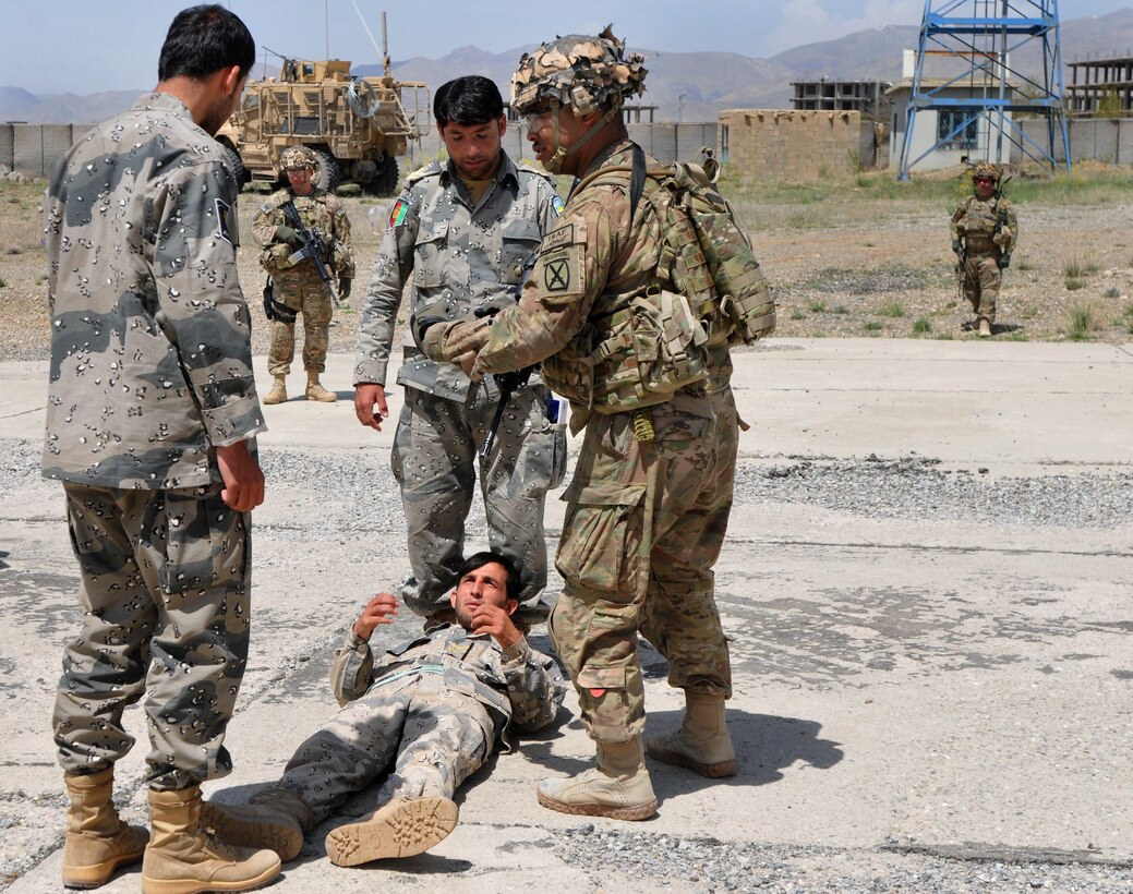 U.S. Army Sgt. 1st  Class Frederick Scott, right, explains how to transport a casualty without a litter to Afghan police during medical evacuation training in Gardez, Afghanistan, April 30, 2014. Scott is assigned to the 10th Mountain Division's Medical Security Force Advise Assist Team, 3rd Brigade Combat Team.