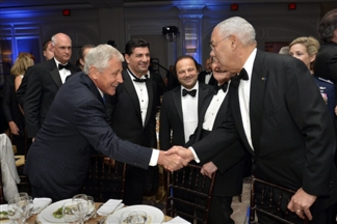 Defense Secretary Chuck Hagel, left, is greeted by former Secretary of State Colin Powell before the start of the 2014 Atlantic Council’s awards ceremony and dinner in Washington, D.C., April 30, 2014. 