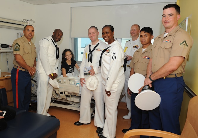 Maddison Novo, 11-year-old and native of Pembroke Pines, Fla., poses with Marines from 2nd Battalion, 6th Marine Regiment, 2nd Marine Division, Marine Corps Base Camp Lejeune, N.C., Naval Mobile Construction Battalion 14, Fort Lauderdale, Fla., and Sailors from the USS New York and Carrier Strike Group 12, during a visit to the Joe DiMaggio Children's Hospital in Fort Lauderdale, Fla., April 30, as part of the 24th Anniversary Fleet Week Port Everglades. 