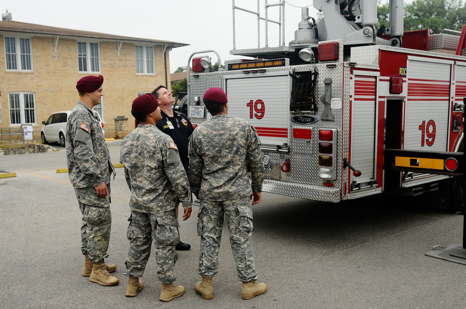 A firefighter with the Austin Fire Department shows his fire truck to U.S. Army National Guard Soldiers in the Texas Military Forces Open House at Camp Mabry in Austin, Texas. Civilian first responders set up tables and greeted visitors to share the partnership they have with Texas Military Forces with the public. 
