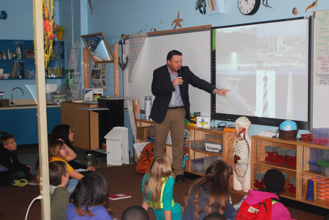 Jason Harrah, Jacksonville Harbor project manager, shows Mayport Elementary Coastal Sciences Academy fifth graders examples of projects that the U.S. Army Corps of Engineers has built across the country.