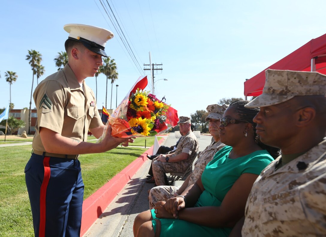 Sgt. Maj. Kenneth Rocquemore’s wife is presented with a bouquet of flowers during the I Marine Expeditionary Force Headquarters Group relief and appointment ceremony aboard Camp Pendleton, Calif., April 29, 2014. Sgt. Maj. Darryl Sisneros replaced Rocquemore after he relinquished his duties to become the senior enlisted advisor of Weapons Field Training Battalion, Marine Corps Recruit Depot, San Diego, Calif.