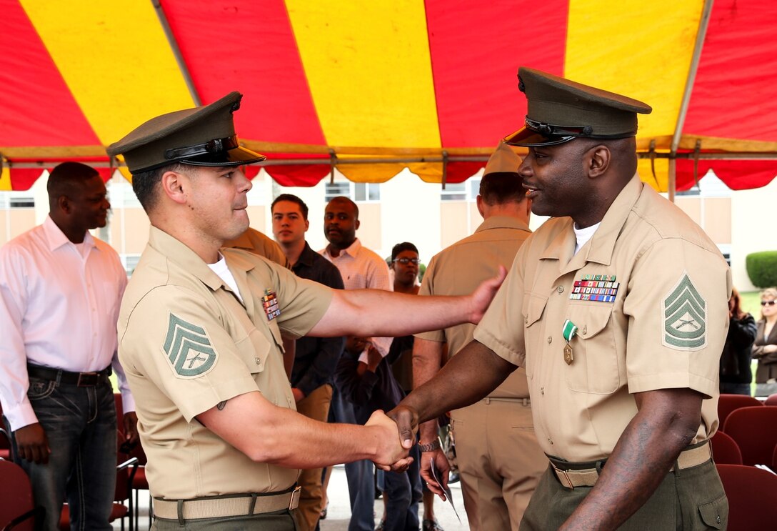 Staff Sgt. Mathew Castel, left, radio frequency chief, congratulates Gunnery Sgt. Treneil L. Smith, logistics chief, both with the 15th Marine Expeditionary Unit, for his service to the Corps after Smith’s retirement ceremony aboard Camp Pendleton, Calif., April 25, 2014. Smith, 40, is from Detroit. (U.S. Marine Corps photo by Cpl. Emmanuel Ramos/Released)