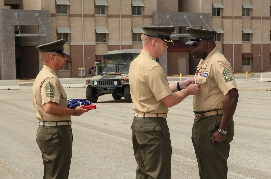 Lieutenant Col. John R. O’Neal, middle, commanding officer, 15th Marine Expeditionary Unit, presents Gunnery Sgt. Treneil L. Smith, logistics chief, 15th MEU, with the Navy and Marine Corps Commendation Medal during his retirement ceremony aboard Camp Pendleton, Calif., April 25, 2014. Smith, 40, is from Detroit. (U.S. Marine Corps photo by Cpl. Emmanuel Ramos/Released)