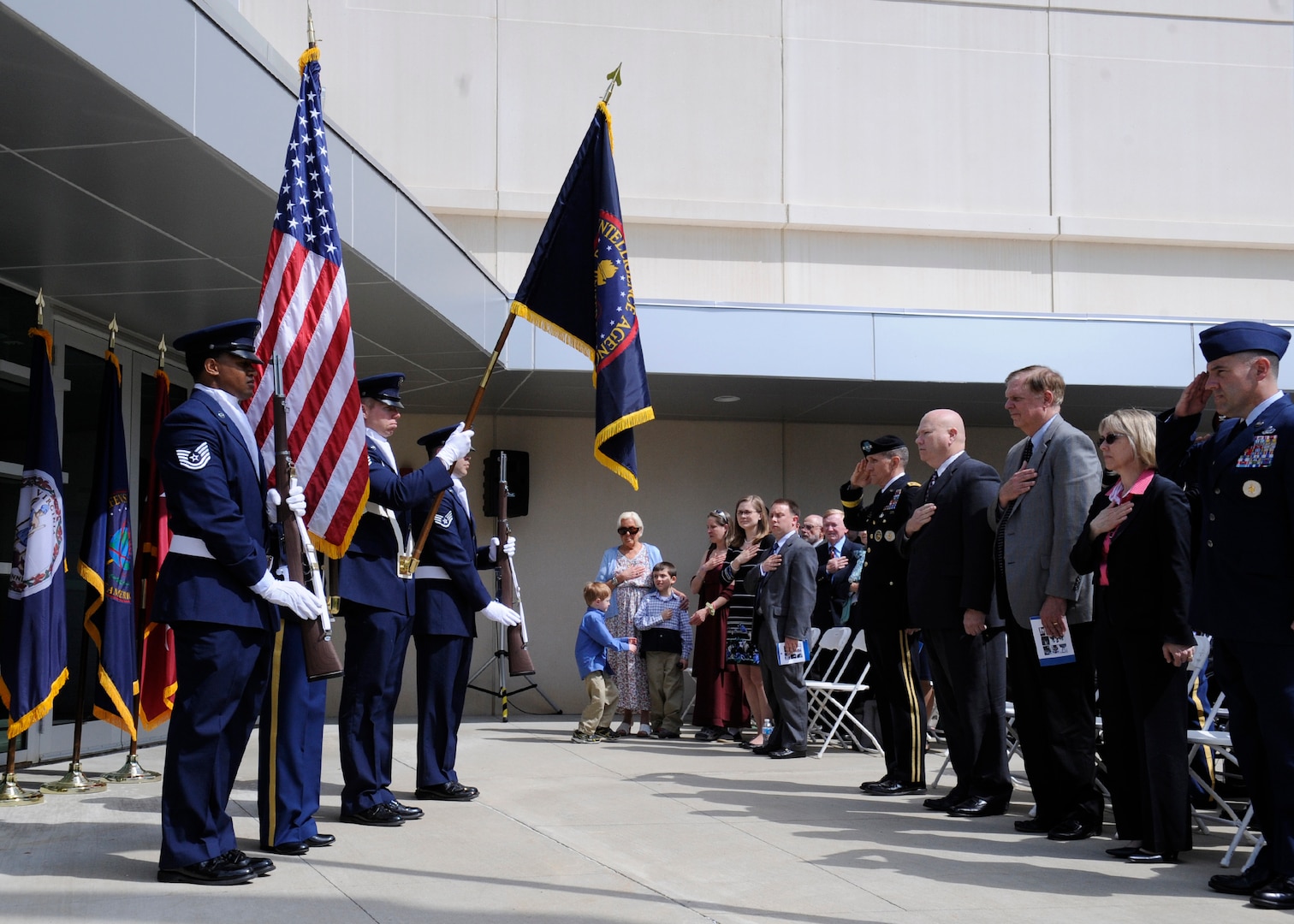 The family of the late Col. James N. Rowe as well as DIA leadership stand for the presentation of the colors during a building dedication ceremony in honor of Rowe at the DIA Field Support Activity Rivanna Station in Charlottesville, Va.