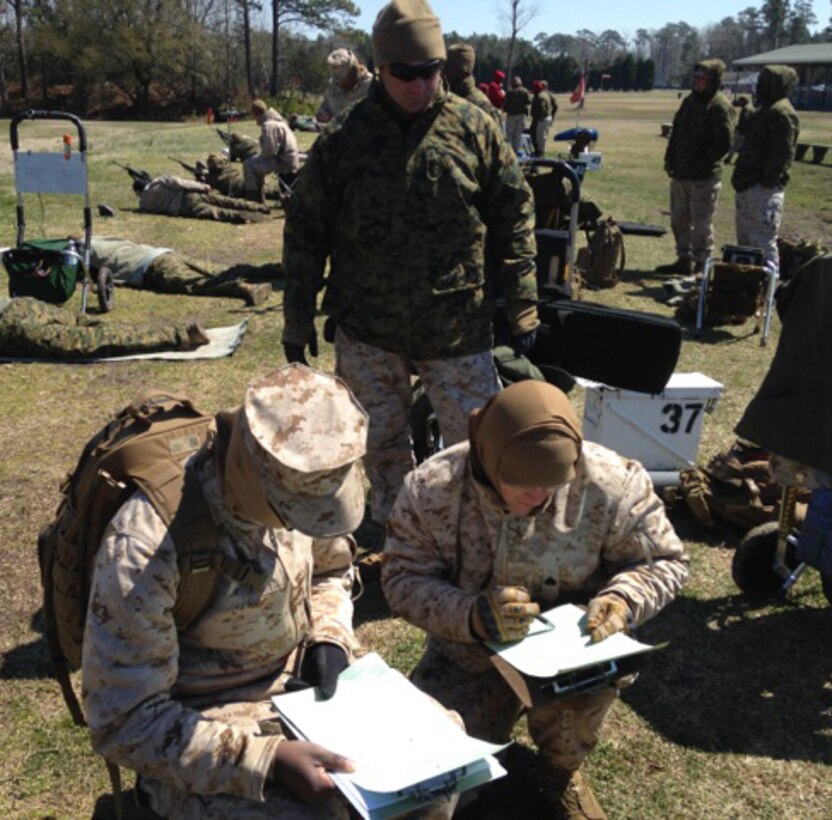 Chief Warrant Officer 3 Stephen Sutton, team member, MCLB Albany Shooting Team, observes the official scorers tallying the final scores for the team competition during the Marine Corps Eastern Division Matches held at Stone Bay, Camp Lejeune, N.C., recently.