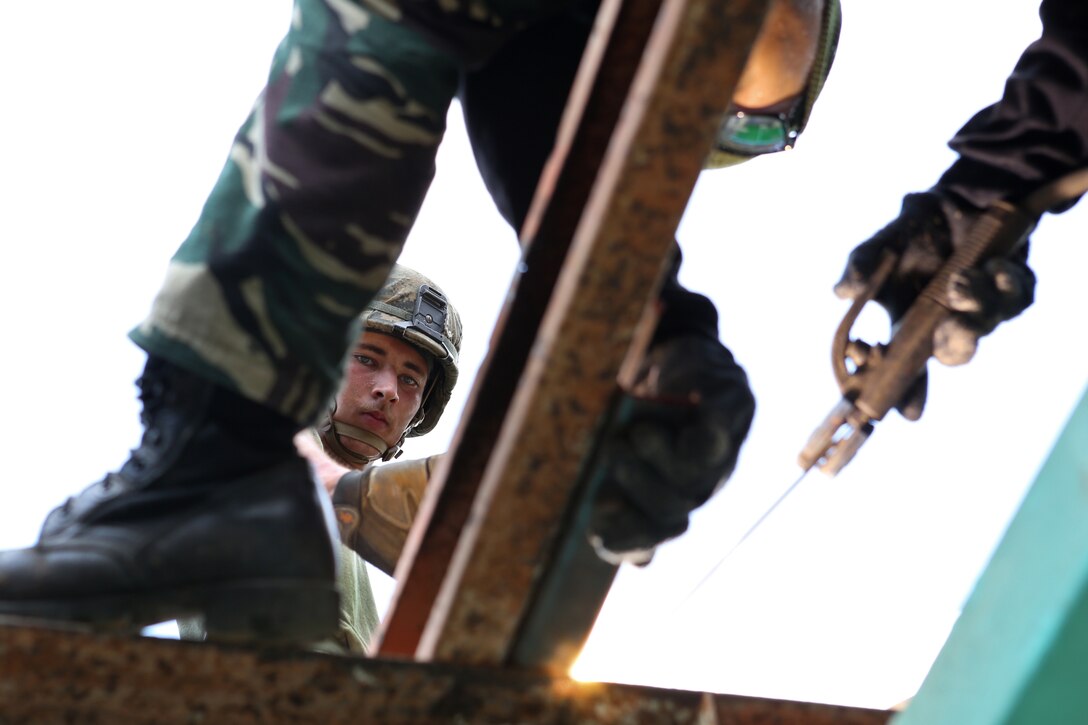 Philippine Army Pfc. Lutiano Neonal, left, assigned to 565th Engineer Combat Battalion, 51st Engineer Brigade, welds a ceiling beam while working on the roof of an elementary school with U.S. Marine Lance Cpl. Patrick O’Neill April 29 during Exercise Balikatan 2014 in Guinobatan, Albay Province, Philippines. This year marks the 30th iteration of the exercise, which is an annual Republic of the Philippines-U.S. military bilateral training exercise and humanitarian civic assistance engagement. The project is one of five engineering civic action project missions being completed by members of the Armed Forces of the Philippines and U.S. armed forces as a part of Balikatan. Neonal is assigned to 565th Engineer Combat Battalion, 51st Engineer Brigade, Armed Forces of the Philippines, and O’Neill is assigned to 9th Engineer Support Battalion, 3rd Marine Logistics Group, III Marine Expeditionary Force.