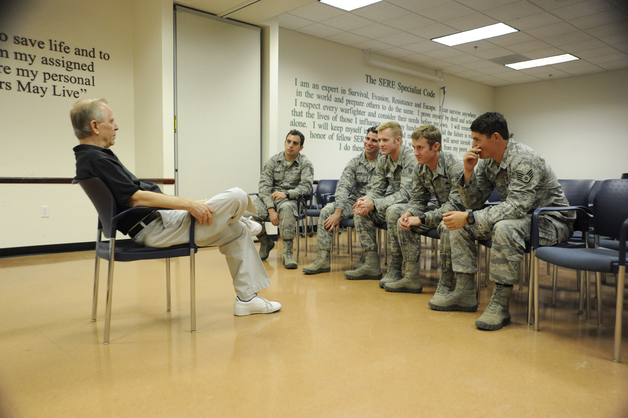 Russell Korne, a Vietnam veteran, tells war stories to pararescuemen from the 48th Rescue Squadron at Davis-Monthan Air Force Base, Ariz., May 1, 2014. Korne visited the pararescuemen to say thank you for saving his life after he had a heart attack in front of the 48th RQS display during the Thunder and Lightning over Arizona event. (U.S. Air Force photo by Airman 1st Class Betty R. Chevalier/Released)