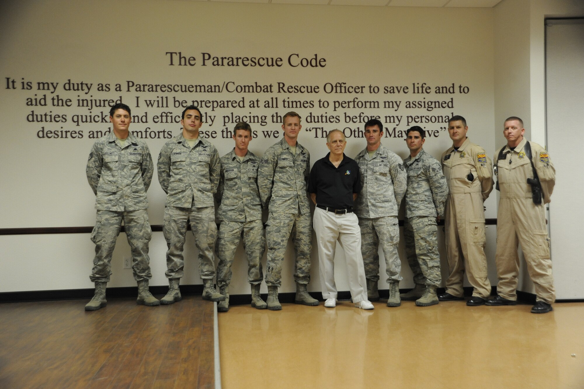 Russell Korne, a Vietnam veteran, poses with pararescuemen and Department of Public Safety officers at Davis-Monthan Air Force Base, Ariz., May 1, 2014. Korne went into cardiac arrest during the Thunder and Lightning over Arizona event April 12 in front of the 48th Rescue Squadron display, where the men immediately ran to his assistance, ultimately saving his life. (U.S. Air Force photo by Airman 1st Class Betty R. Chevalier/Released)