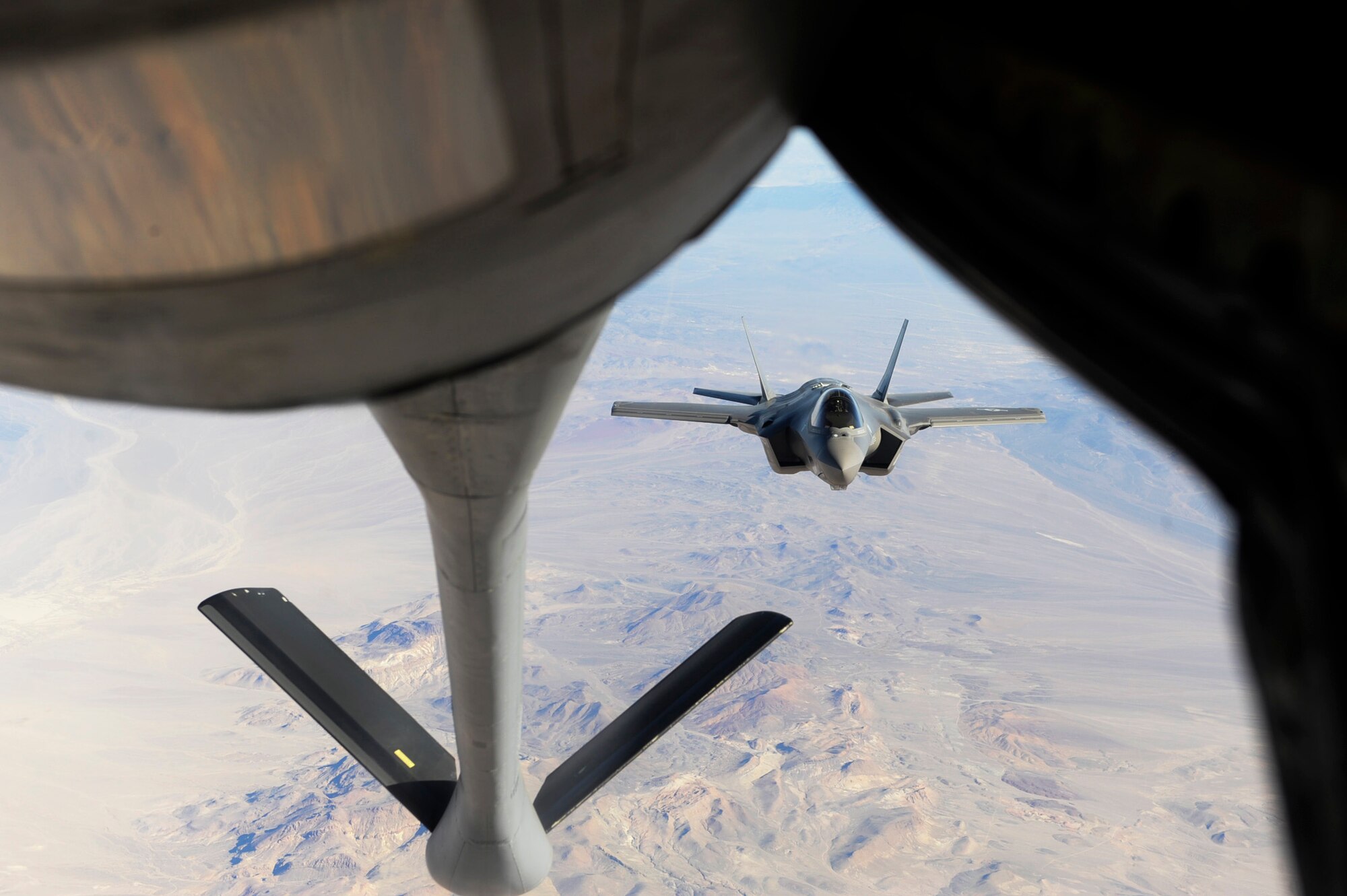 A U.S. Air Force F-35 Lightning II assigned to the 31st Test and Evaluation Squadron from Edwards Air Force Base, Calif. moves into position for mid-air refueling behind a KC-135 Stratotanker assigned to the 344th Air Refueling Squadron from McConnell AFB, Kan. April 29, 2014, over the California desert. With a range of 5,000 miles, the KC-135 can stay airborne for an extended period of time and provide mid-air refueling for a variety of different aircraft. (U.S. Air Force photo by Airman 1st Class Thomas Spangler)