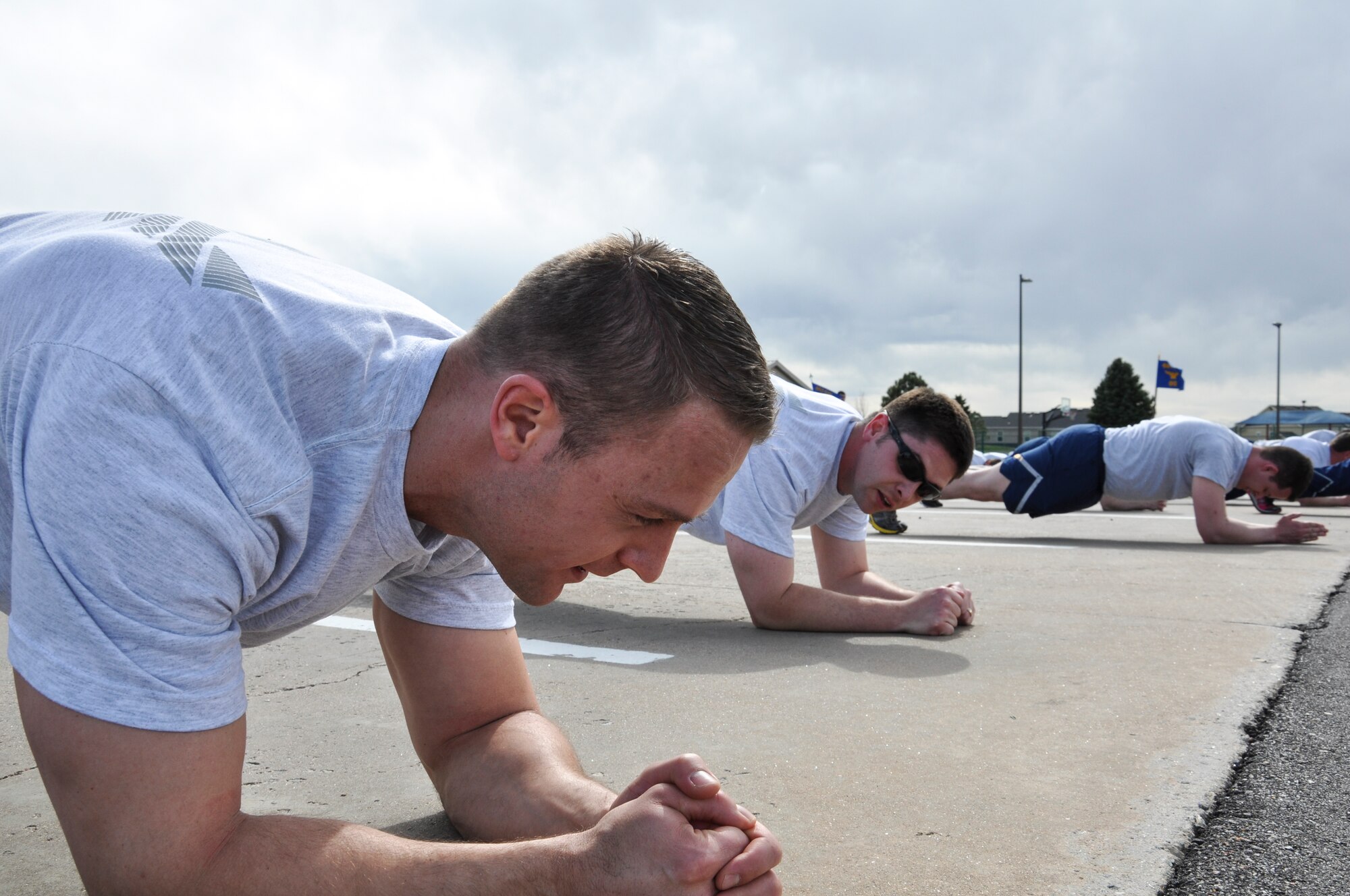 Capt. Luke McPherson and Capt. Eric McCutchen, both from the 460th Space Wing legal office, perform planks during a quick stop of the 2.5-mile WarFit formation run April 25, 2014, at Buckley Air Force Base, Colo. The workout included segments on base history and stops for anaerobic exercises. (U.S. Air Force photo by Staff Sgt. Nicholas Rau/Released)