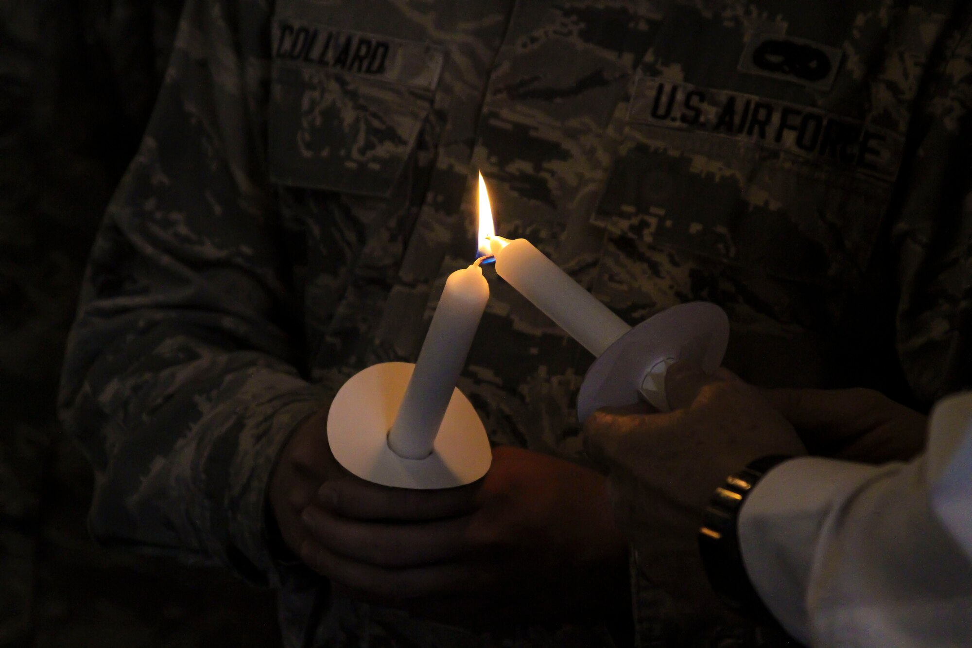 The 12th Air Force (Air Forces Southern) Holocaust Remembrance Committee light a candle in remembrance of the victims of the Holocaust during the Holocaust Day of Remembrance on Davis-Monthan AFB, Ariz., May 2, 2014.  Nine candles were lit representing the nine-million victims of the Holocaust. (U.S. Air Force photo by Tech. Sgt. Heather R. Redman/Released)