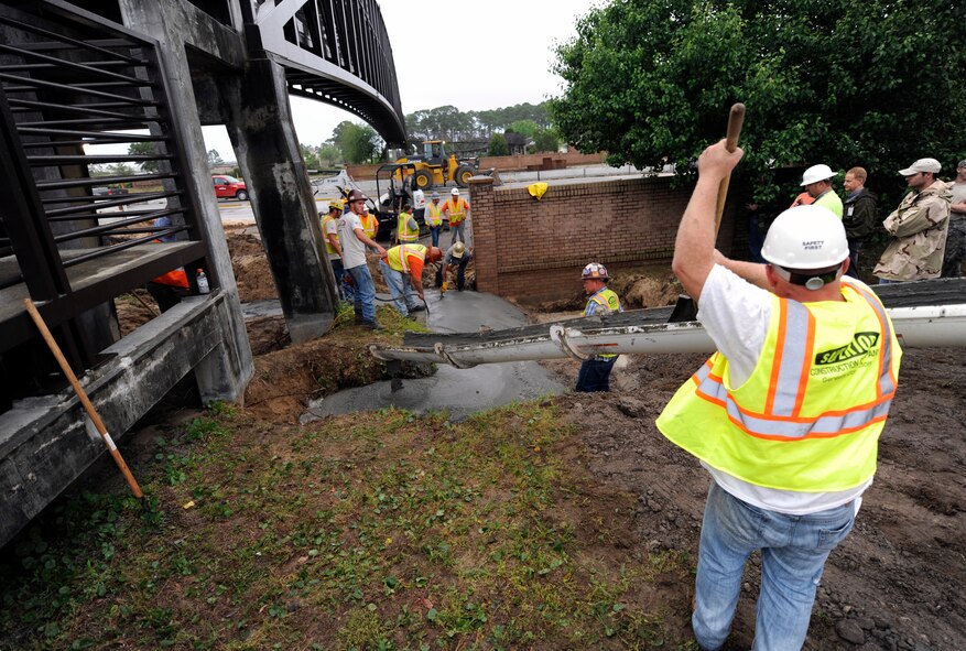 Florida Department of Transportation personnel repair the foundation of the footbridge at Hurlburt Field, Fla., April 30, 2014. Severe weather caused floods, which damaged roads, fences and other property on the base. (U.S. Air Force photo/Staff Sgt. Jeff Andrejcik)