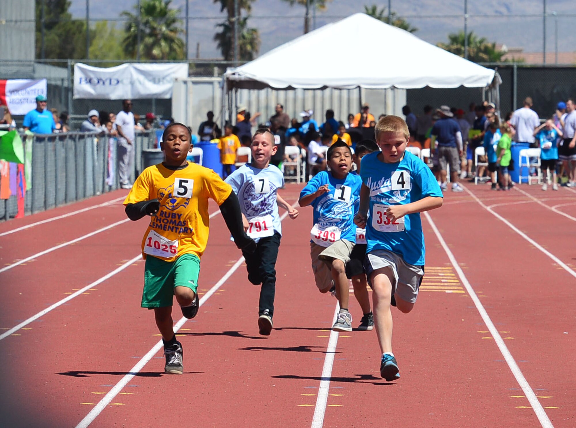 Boys competing in the 50-meter race push themselves toward the finish line during the opening ceremony of the Nevada Special Olympics at Cheyenne High School in Las Vegas May 1, 2014. More than 240 Airmen from Nellis and Creech Air Force Bases volunteered their time during the two-day event to help unify the community and set an example through fitness and sports play.