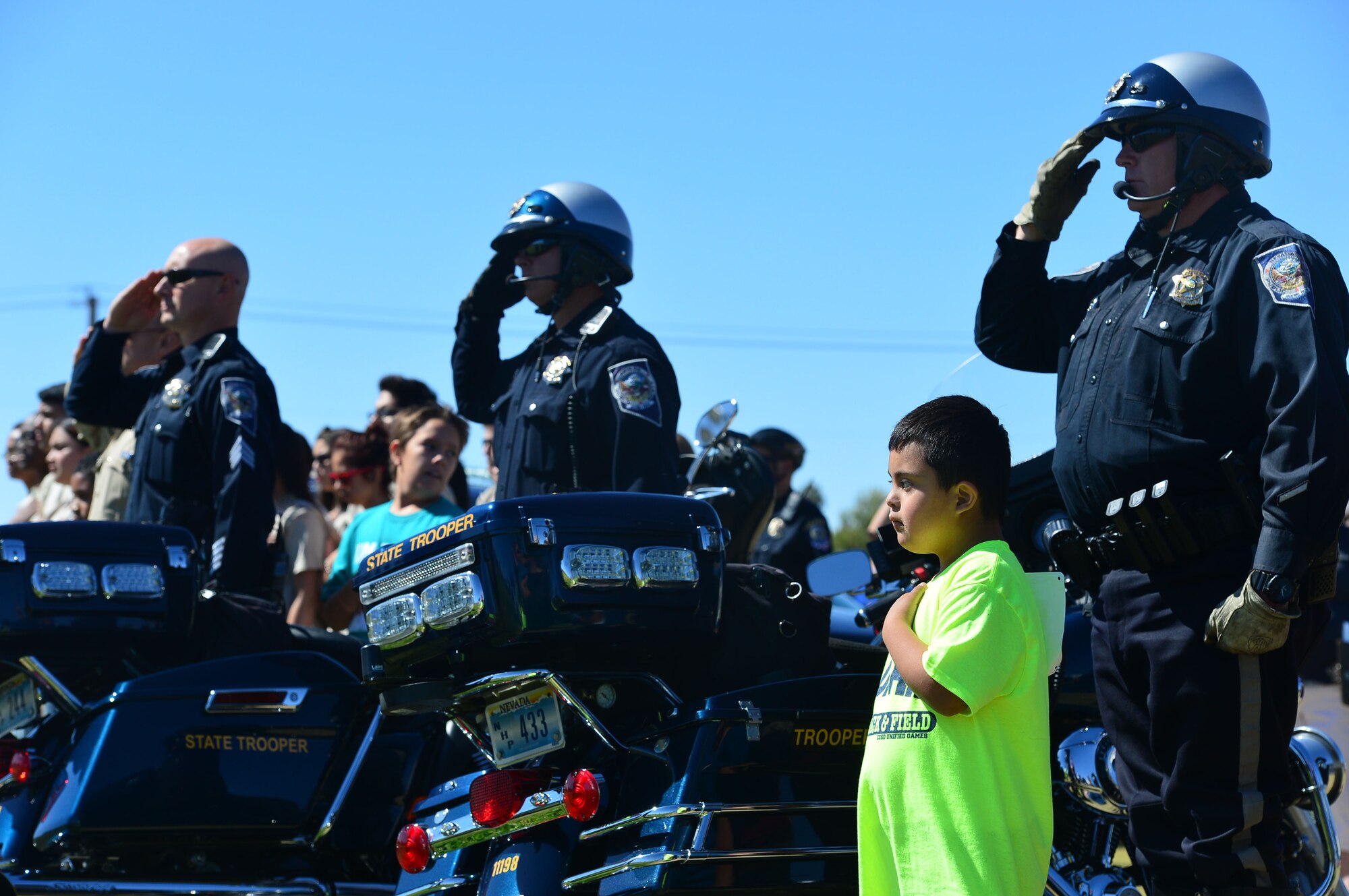 Ethan Jauregui, seven, a Goldfarb Elementary School student, places his hand over his heart while Las Vegas Metro Police Officers salute during the opening ceremony of the Nevada Special Olympics at Cheyenne High School in Las Vegas May 1, 2014. More than 1,900 special needs athletes from 40 local schools attended the two-day event and participated in various track and field events.