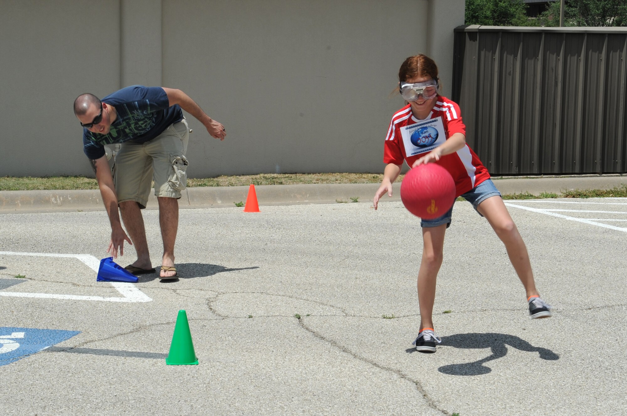 GOODFELLOW AIR FORCE BASE, Texas -- Senior Airman Charles A. Metts III, 17th Medical Operations Squadron Alcohol and Drug Abuse Prevention and Treatment technician, picks up cones as a youth dribbles the ball during the 4th Annual Sexual Assault and Response Coordinator Challenge here April 26. Participants dribbled the ball around the cones while wearing glasses that distort vision. (U.S. Air Force photo/ Staff Sgt. Laura R. McFarlane)