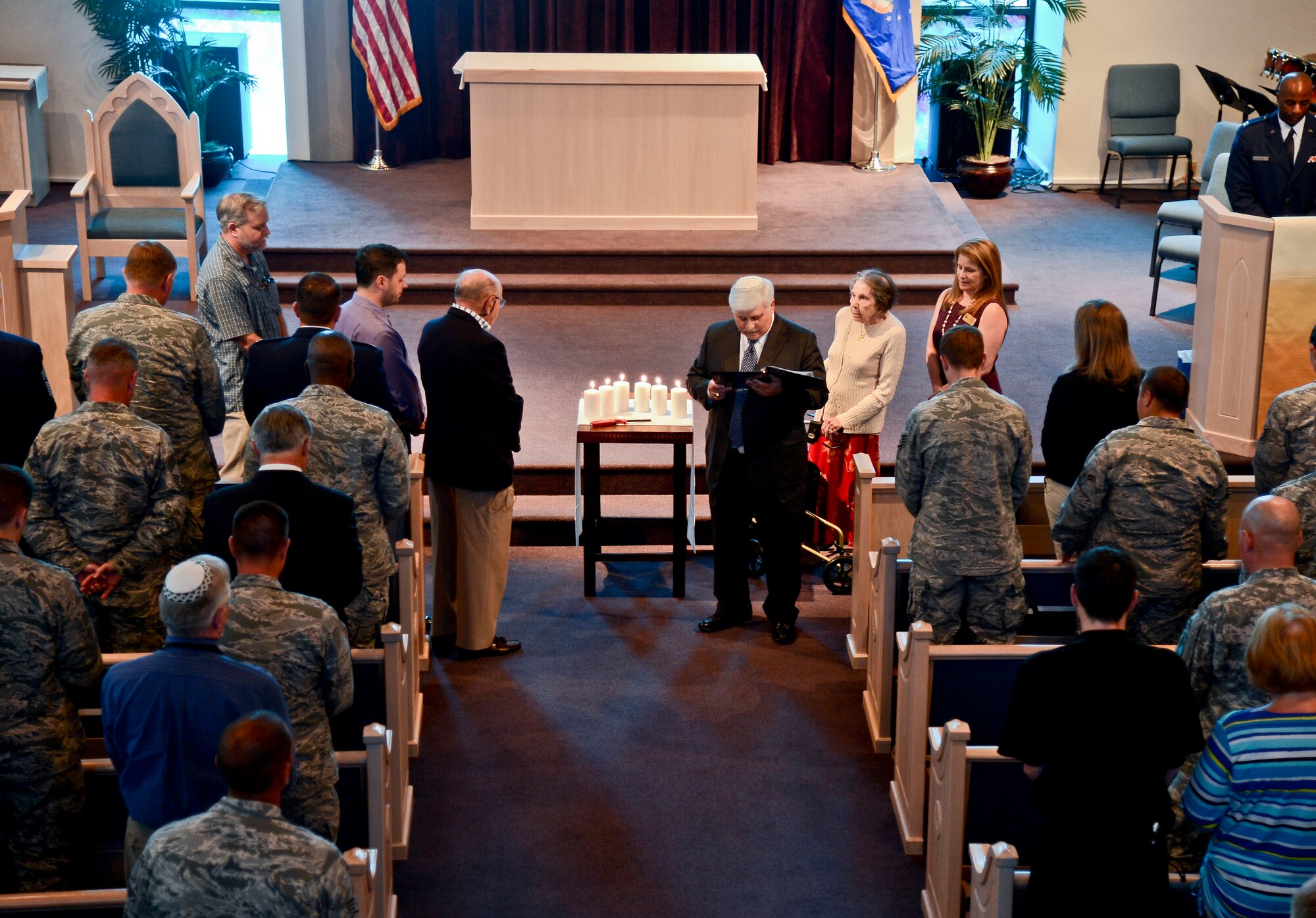 Rabbi Richard Birnholz, Senior Rabbi of Congregation Schaarai Zedek, reads as the audience looks on during the Holocaust Remembrance “Confronting the Holocaust: American Responses” at MacDill Air Force Base, Fla., April 28, 2014. Birnholz presided over the event’s invocation, candle lighting and readings. (U.S. Air Force photo by Airman 1st Class Vernon L. Fowler Jr./Released)