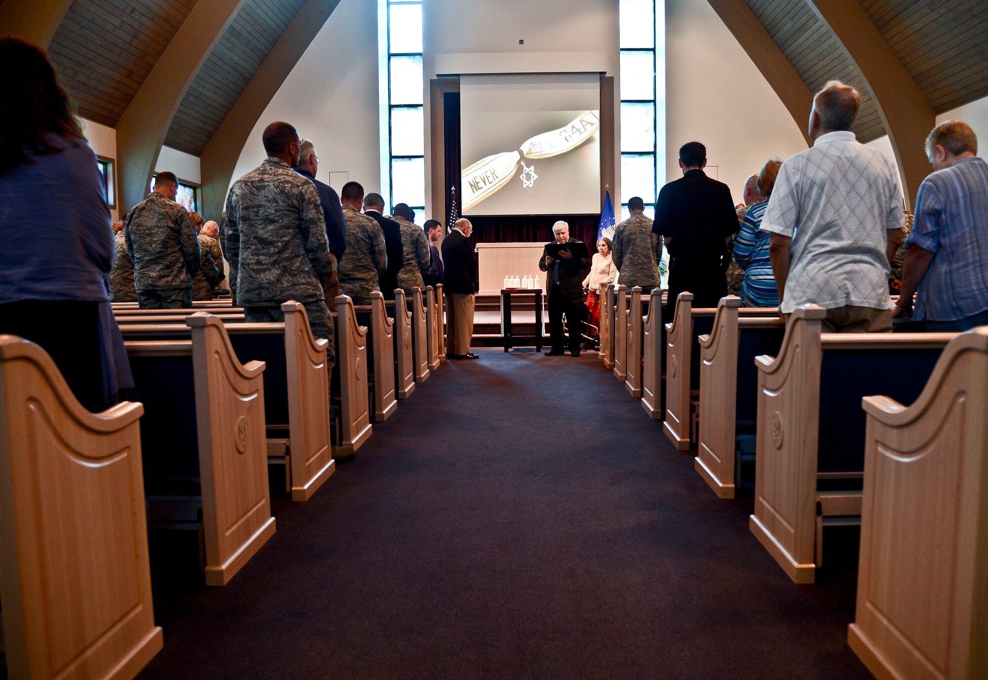 Rabbi Richard Birnholz, Senior Rabbi of Congregation Schaarai Zedek, reads as the audience looks on during the Holocaust Remembrance “Confronting the Holocaust: American Responses” at MacDill Air Force Base, Fla., April 28, 2014. Birnholz presided over the event’s invocation, candle lighting and readings. (U.S. Air Force photo by Airman 1st Class Vernon L. Fowler Jr./Released)