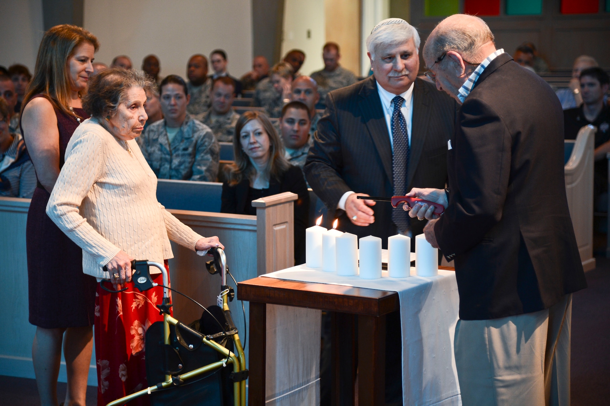 (Inside Left) Sally Riba and Gary Silvers (Far Right), Holocaust survivors, light candles during the Holocaust Remembrance “Confronting the Holocaust: American Responses” at MacDill Air Force Base, Fla., April 28, 2014. Silvers and Riba attended the event as the guests of honor. (U.S. Air Force photo by Airman 1st Class Vernon L. Fowler Jr./Released)