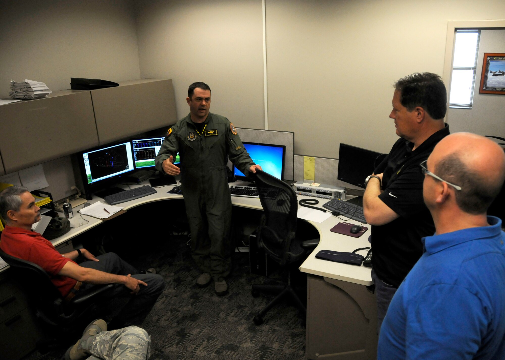 Lt. Col. Surya Frickel, 419th Fighter Wing pilot, explains a training mission to a group of Utah civic leaders who traveled to Florida to learn more about the wing's annual tour training. Frickel said the screen behind him displays a real-time aerial view of the battle space with red dots showing designated “enemy” aircraft. The goal is for pilots from the 419th FW and 85th Training and Evaluation Squadron to participate in the air-to-air drill that simulates the same integrated force they could expect in a deployed environment. After their flight, pilots review the footage and evaluate tactics and performance. (U.S. Air Force photo/Senior Airman Allen Stokes)
