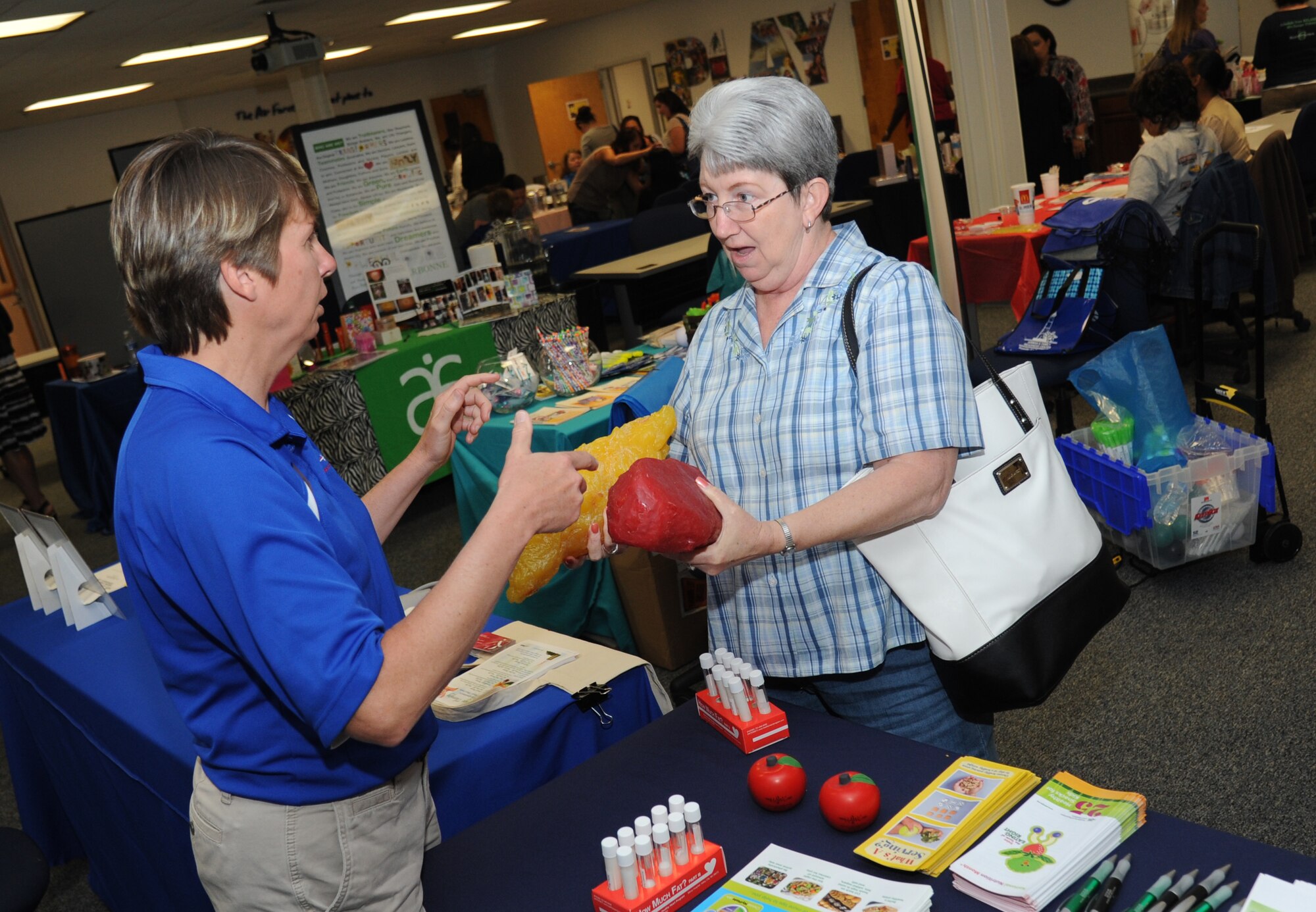 Terri Jordan, 81st Aerospace Medicine Squadron health program manager, provides an overview of the difference of a five-pound mass of fatty tissue versus a five-pound mass of muscle tissue to the spouse of retired Staff Sgt. John Wilkinson during Pamper Me Day for military spouses May 1, 2014, at the Sablich Center, Keesler Air Force Base, Miss.  Keesler’s Airman & Family Readiness Center has hosted the event for the past 10 years, offering spouses free manicures, hair styling, makeup and massages.  (U.S. Air Force photo by Kemberly Groue)