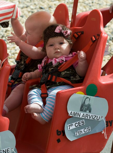 Nathalia Arvizu, daughter of Staff Sgts. Saul and Ginny Arvizu, rides in the Month of the Military Child parade April 29, 2014, at Dyess Air Force Base, Texas. The Child Development Center held its annual parade to celebrate the Month of the Military Child. Approximately 350 children and their parents participated in the parade. (U.S. Air Force photo by Airman 1st Class Kylsee Wisseman/Released)