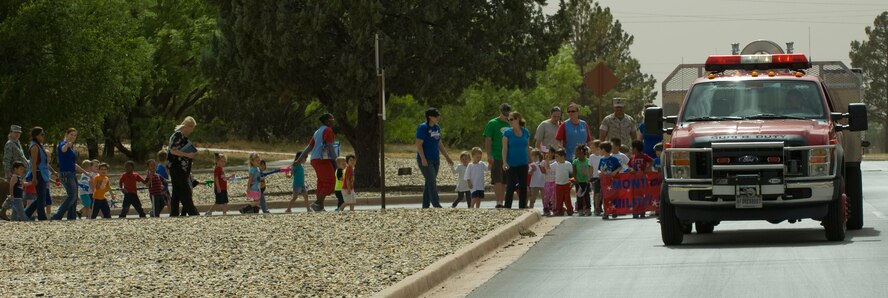 Dyess firefighters lead the Month of the Military Child parade at the Child Development Center April 29, 2014, at Dyess Air Force Base, Texas. Since 1986, April has been designated as the Month of the Military child to recognize the contributions, courage and resilience of the youngest members of the military community. (U.S. Air Force photo by Airman 1st Class Kylsee Wisseman/Released)