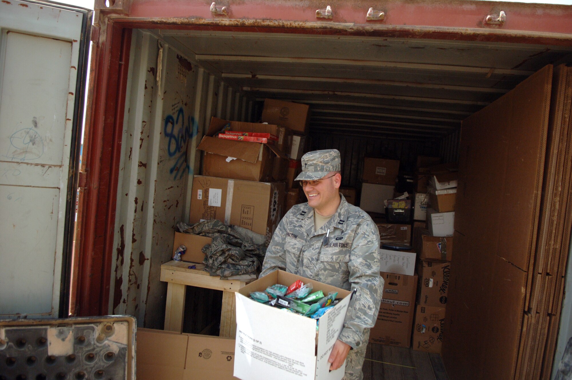 Capt. (Chaplain) David Haltom, 732nd Air Expeditionary Group chaplain, carries out a box of donations to sort through during a 2009 deployment to Iraq. Haltom came to Travis Air Force Base in 2013. (U.S. Air Force photo/Staff Sgt. Dilia Ayala)
