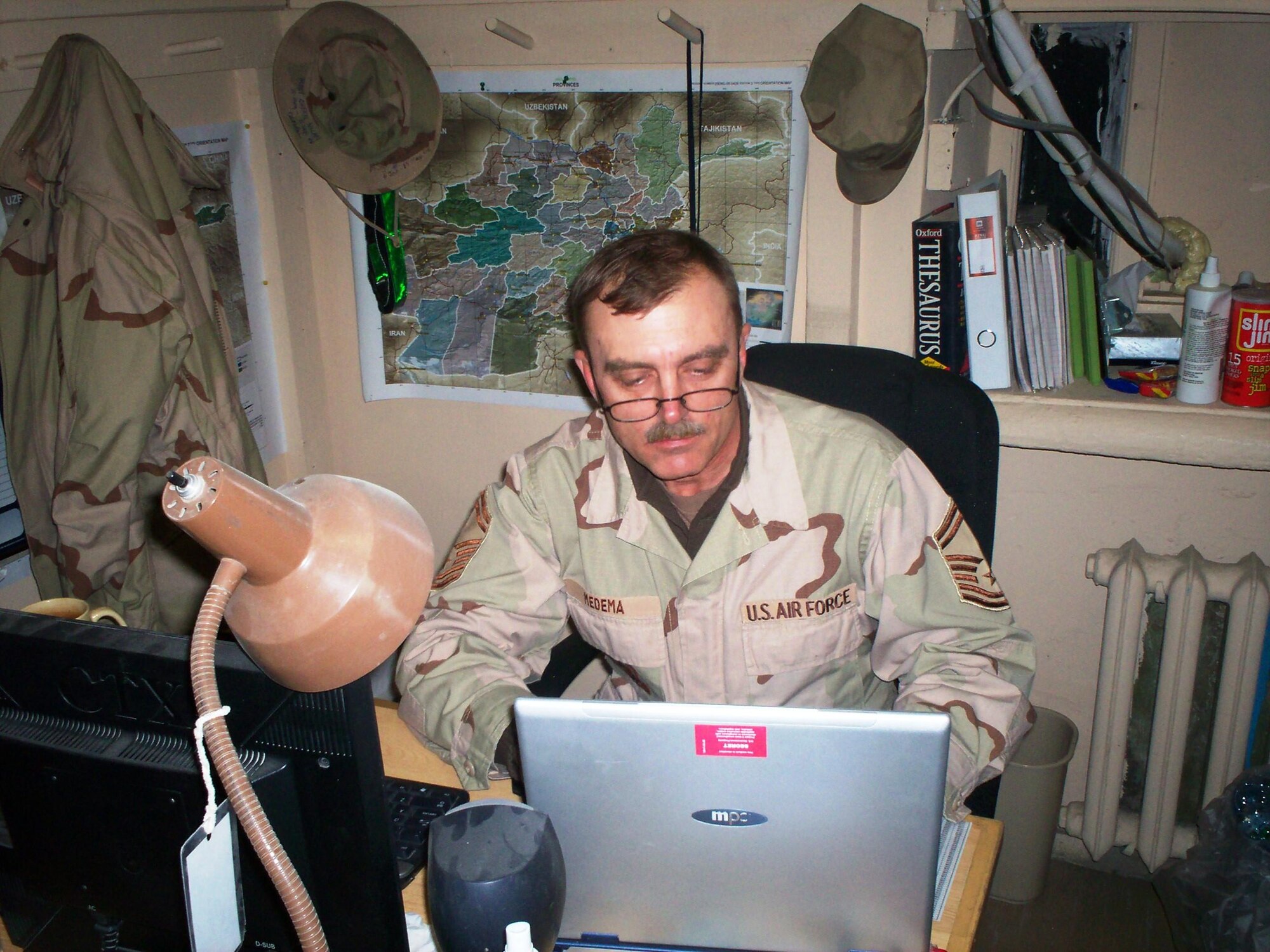 Then Senior Master Sgt. William Medema, scans through documents during a deployment to Bagram Air Field, Afghanistan, in 2006.  Medema enlisted in the Army National Guard in 1975 before joining the Air Force as a supply troop in 1984. (Courtesy photo)