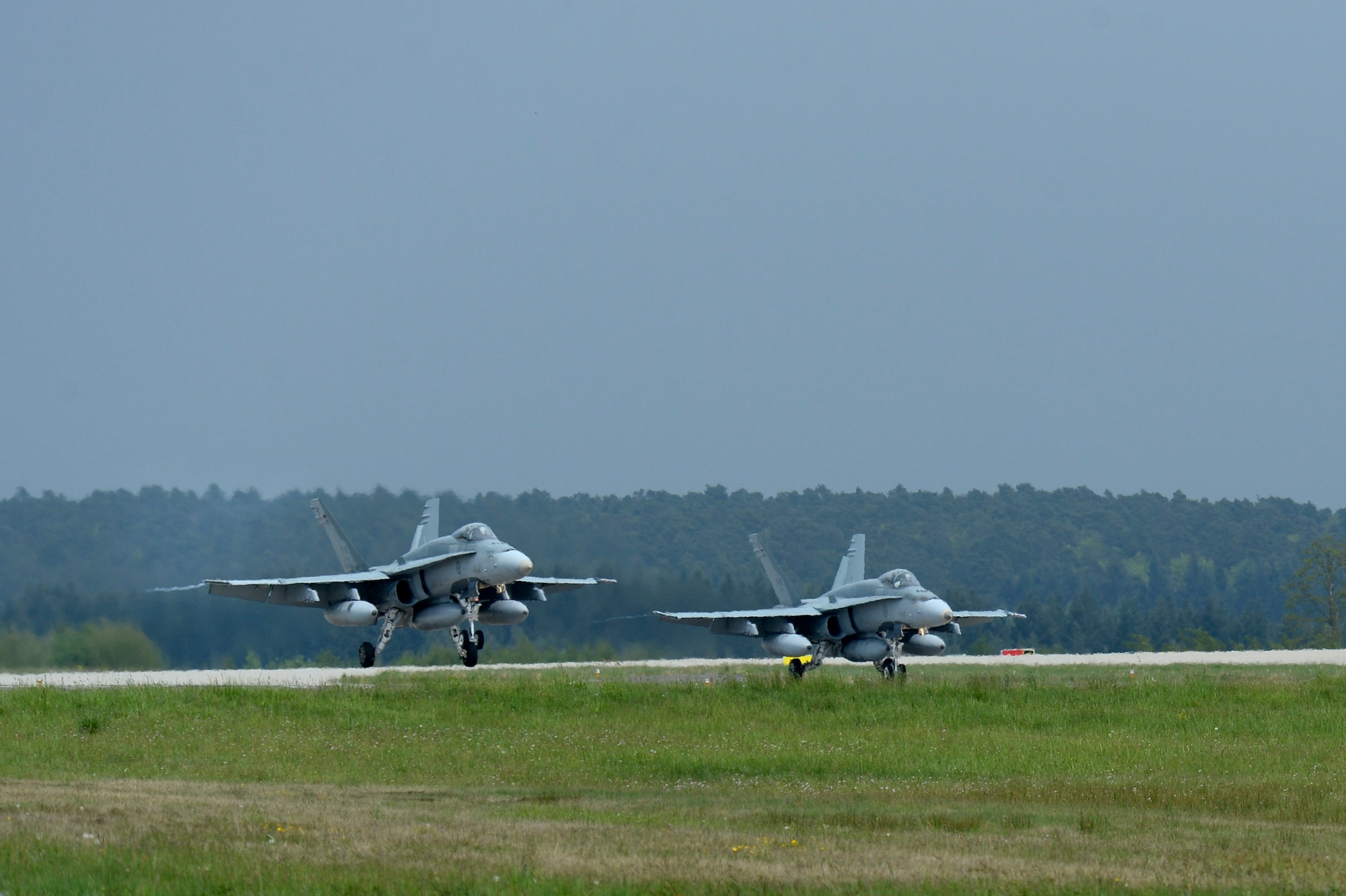 Royal Canadian Air Force pilots land CF-18 Hornet fighter aircraft on the flightline May 1, 2014, at Spangdahlem Air Base, Germany. The fighter aircraft, along with support personnel, are travelling to Romania in order to conduct training activities as part of NATO reassurance measures to Central and Eastern Europe. The 52nd Fighter Wing and 726th Air Mobility Squadron at Spangdahlem are forward-based, with ready forces equipped to further enable NATO operations and enhance partner readiness. (U.S. Air Force photo by Senior Airman Rusty Frank/Released)