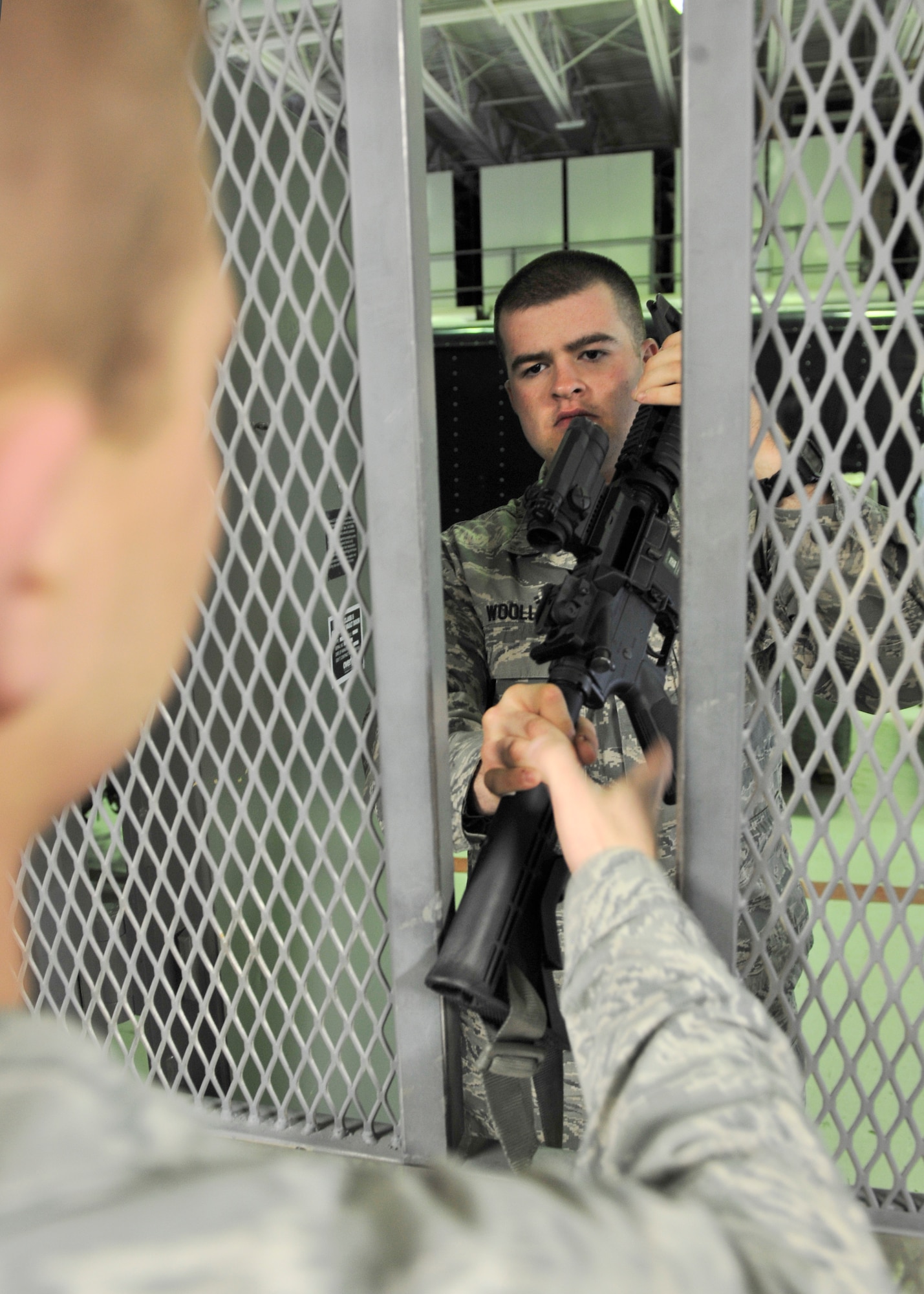 Airman 1st Class Zackary Woolley, 354th Civil Engineer Squadron emergency management apprentice, returns an M-4 carbine to Senior Airman Travis Marshall, 354th CES expeditionary engineering programs manager, April 24, 2014, Eielson Air Force Base, Alaska. During a recent operational readiness exercise, the 354th CES unit deployment managers issued over 100 weapons to Airmen. (U.S. Air Force photo by Senior Airman Ashley Nicole Taylor/Released)