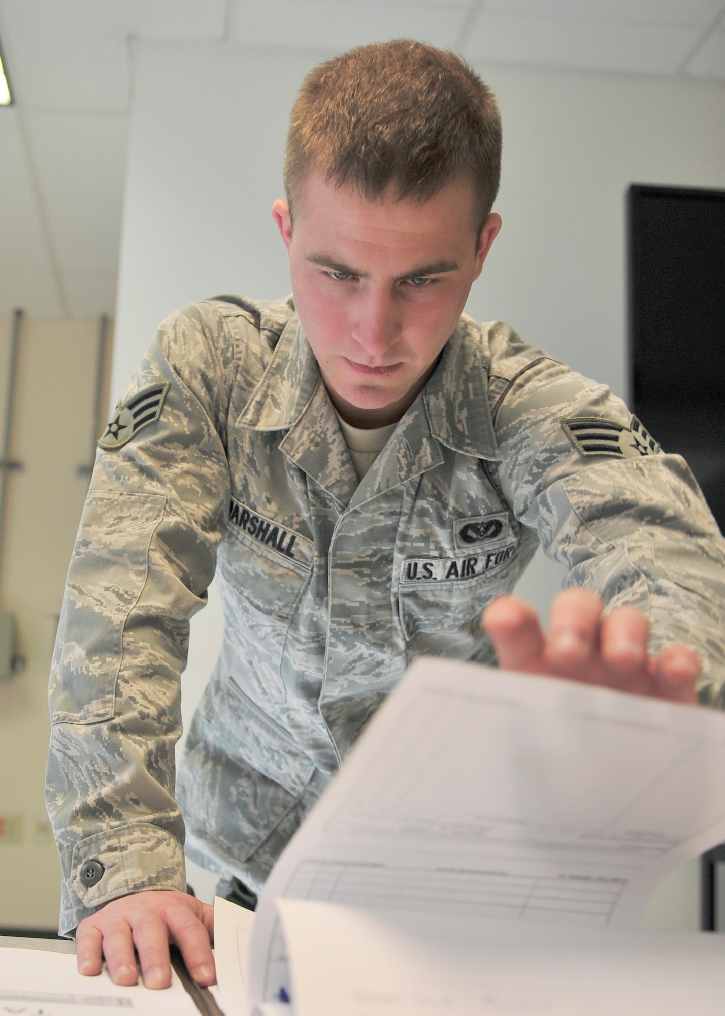 Senior Airman Travis Marshall, 354th Civil Engineer Squadron expeditionary engineering programs manager, reviews a mobility folder April 24, 2014, Eielson Air Force Base, Alaska. Marshall tracks over 8,000 training items to ensure members of the 354th CES are eligible to deploy. (U.S. Air Force photo by Senior Airman Ashley Nicole Taylor/Released)