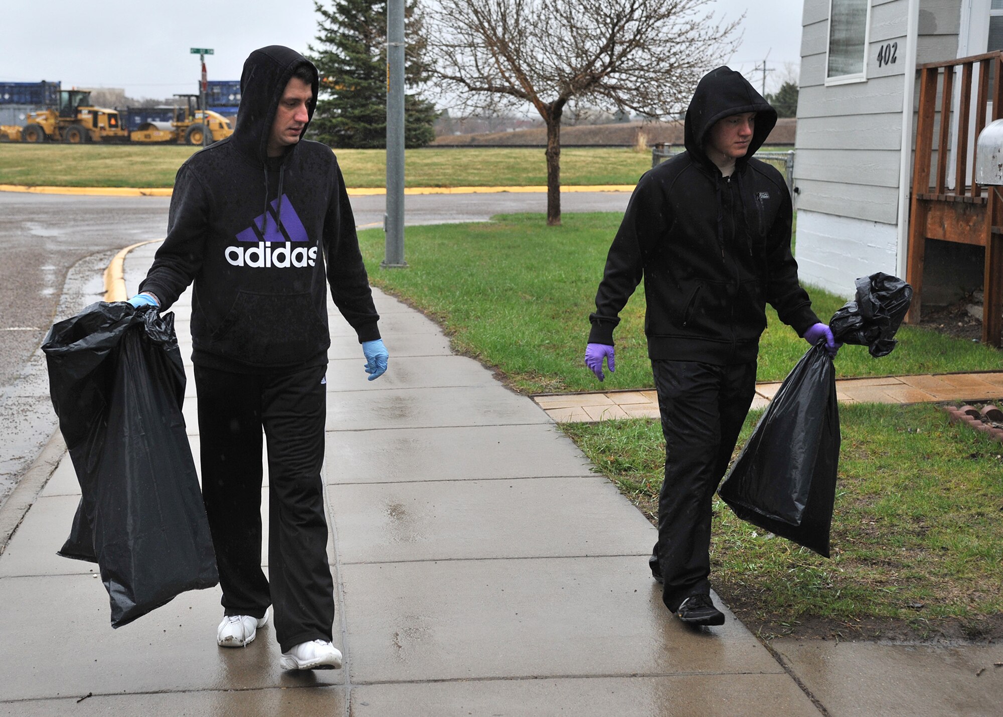 From left to right, Staff Sgt. Josh Tolaro and Airman Nathaniel Morris, both 341st Medical Group members, collect loose trash on the west side of Great Falls on April 26 during the annual MApril cleanup. (U.S. Air Force photo / John Turner) 