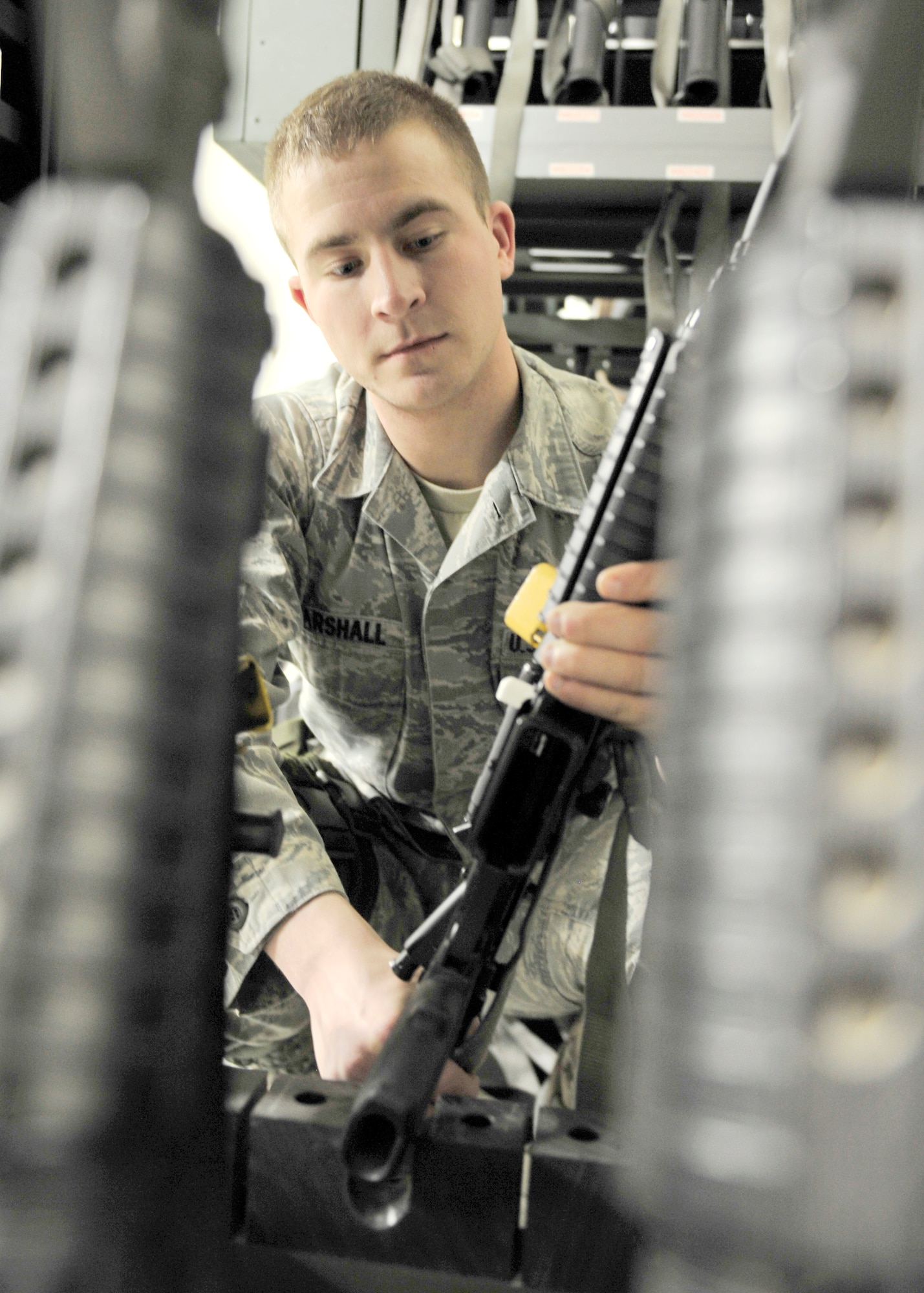 Senior Airman Travis Marshall, 354th Civil Engineer Squadron expeditionary engineering programs manager, organizes M-4 carbines after an operational readiness exercise April 24, 2014, Eielson Air Force Base, Alaska. Marshall works with the 354th CES unit deployment managers to assist in deploying over 300 Airmen assigned to the squadron. (U.S. Air Force photo by Senior Airman Ashley Nicole Taylor/Released)